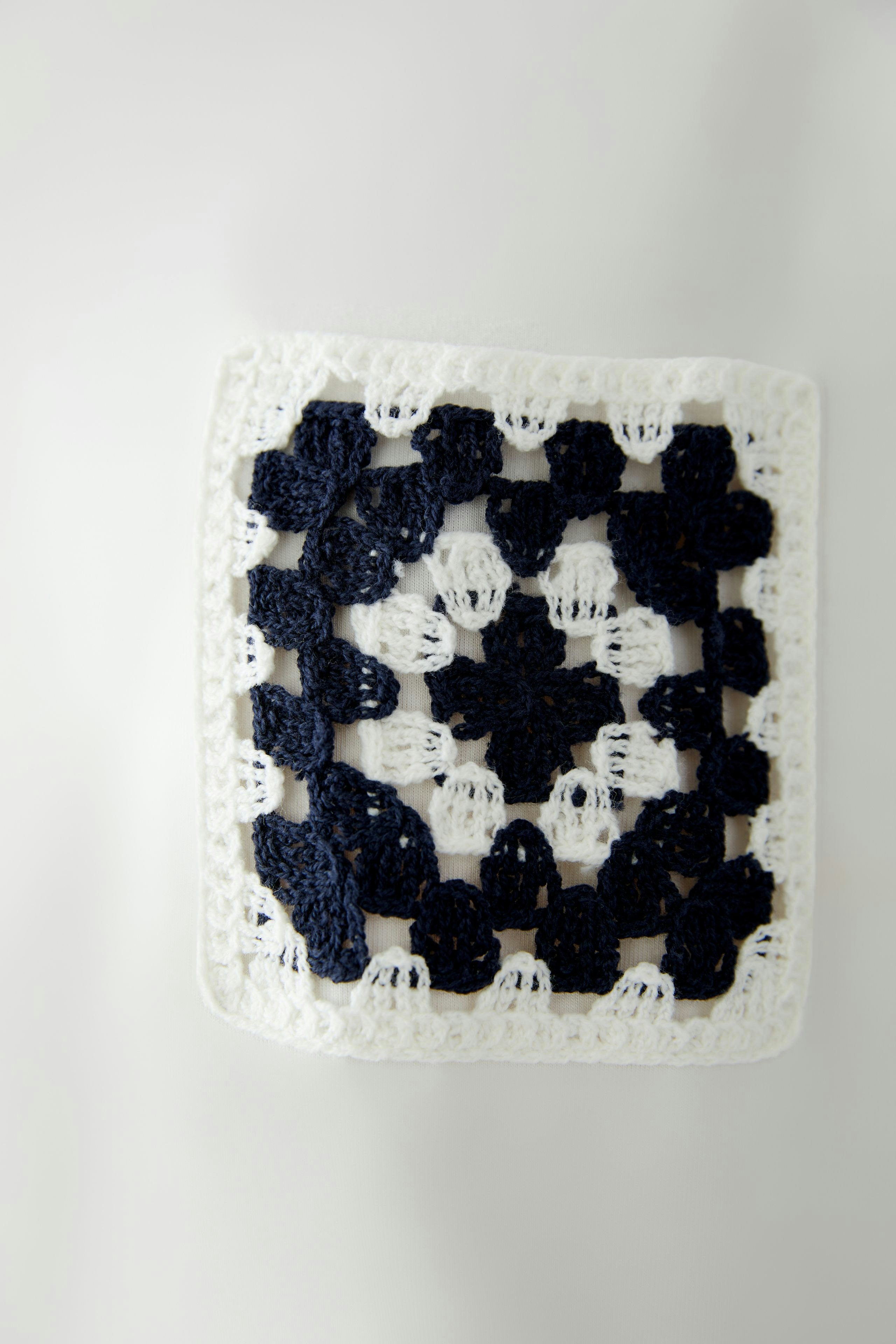 Stylish women's T-shirt featuring a unique crochet design in navy and white.