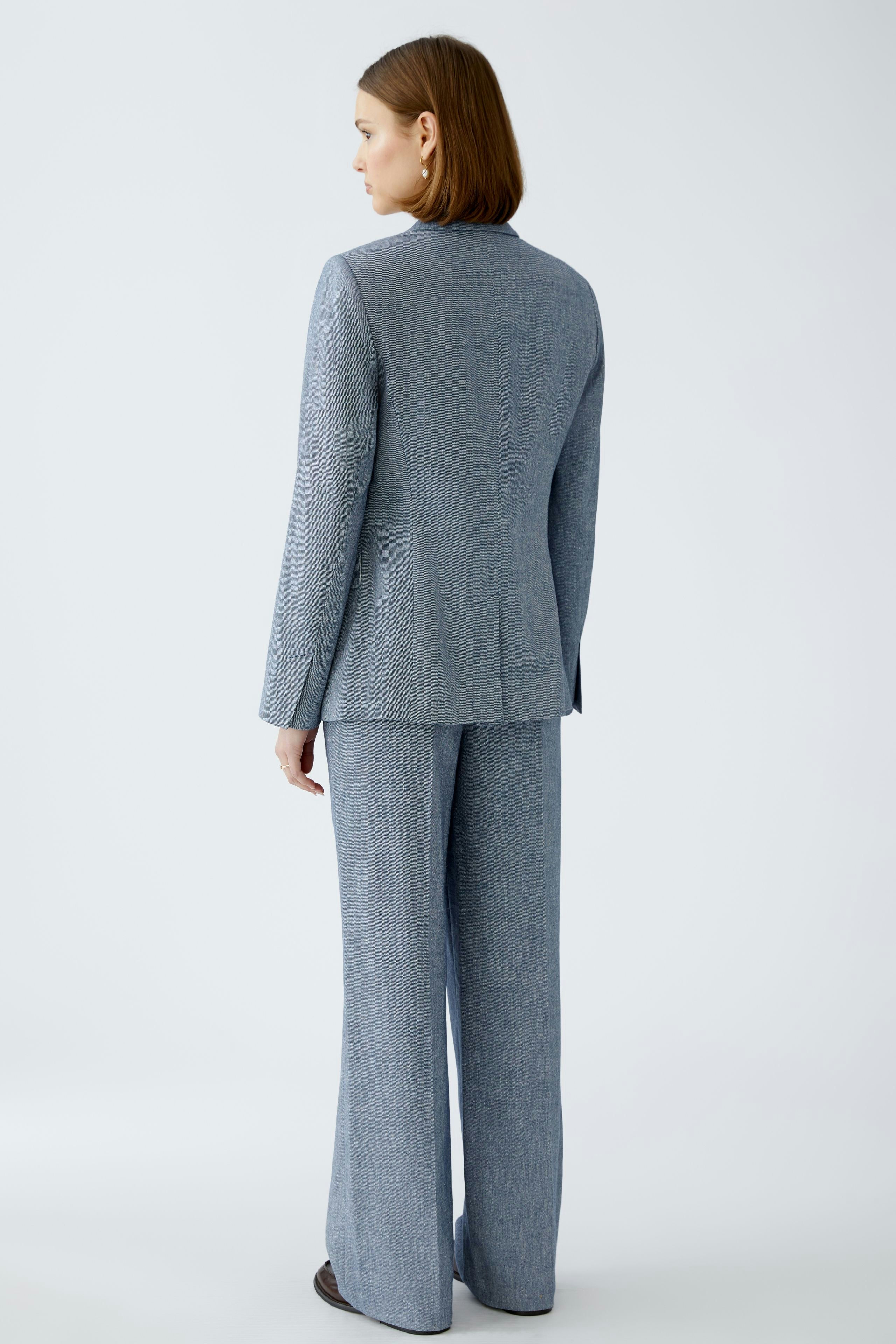 Elegant women's blazer: A woman in a tailored blue blazer, showcasing a sophisticated and modern style.