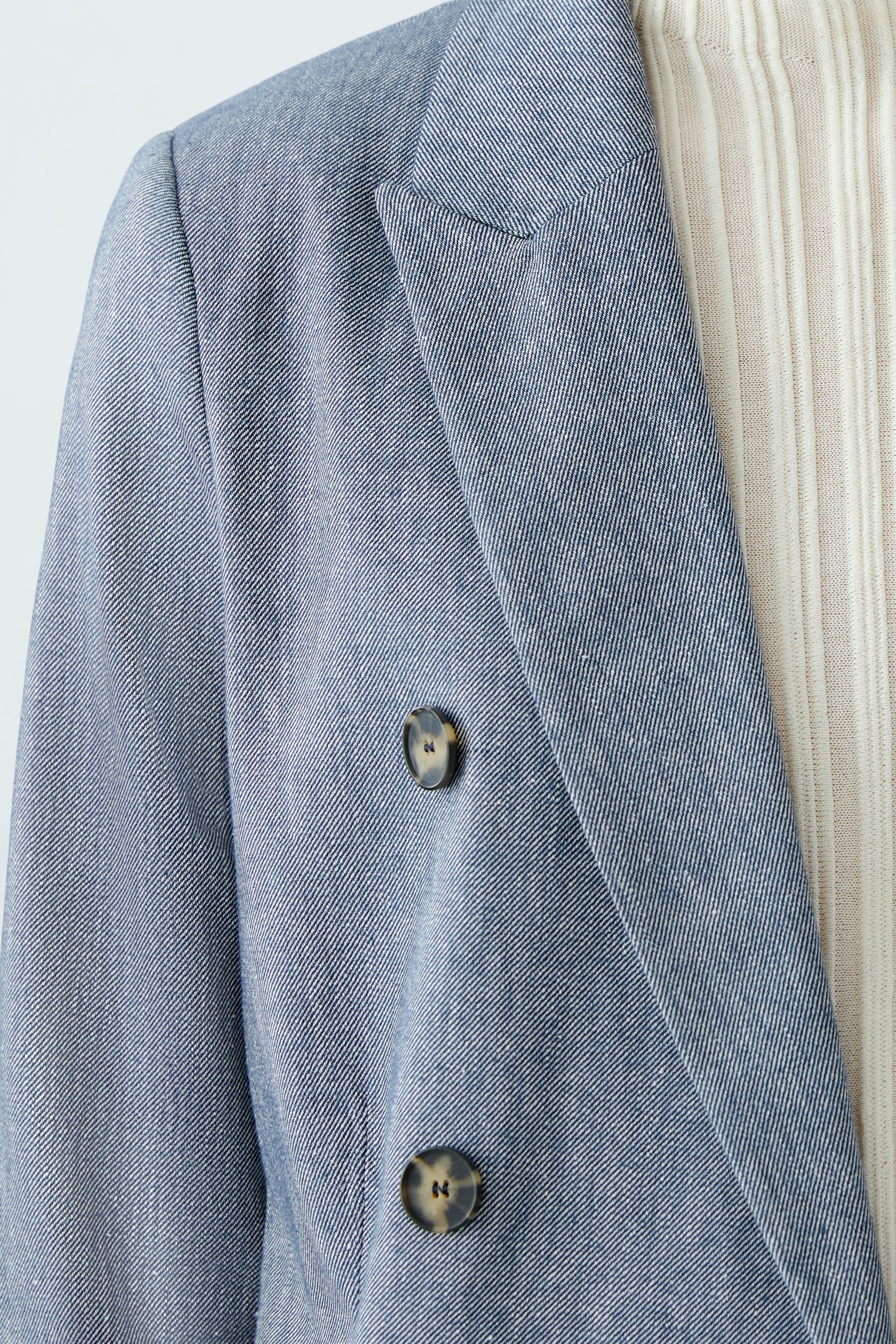 Stylish women's blazer in light blue with double buttons, perfect for a chic look.