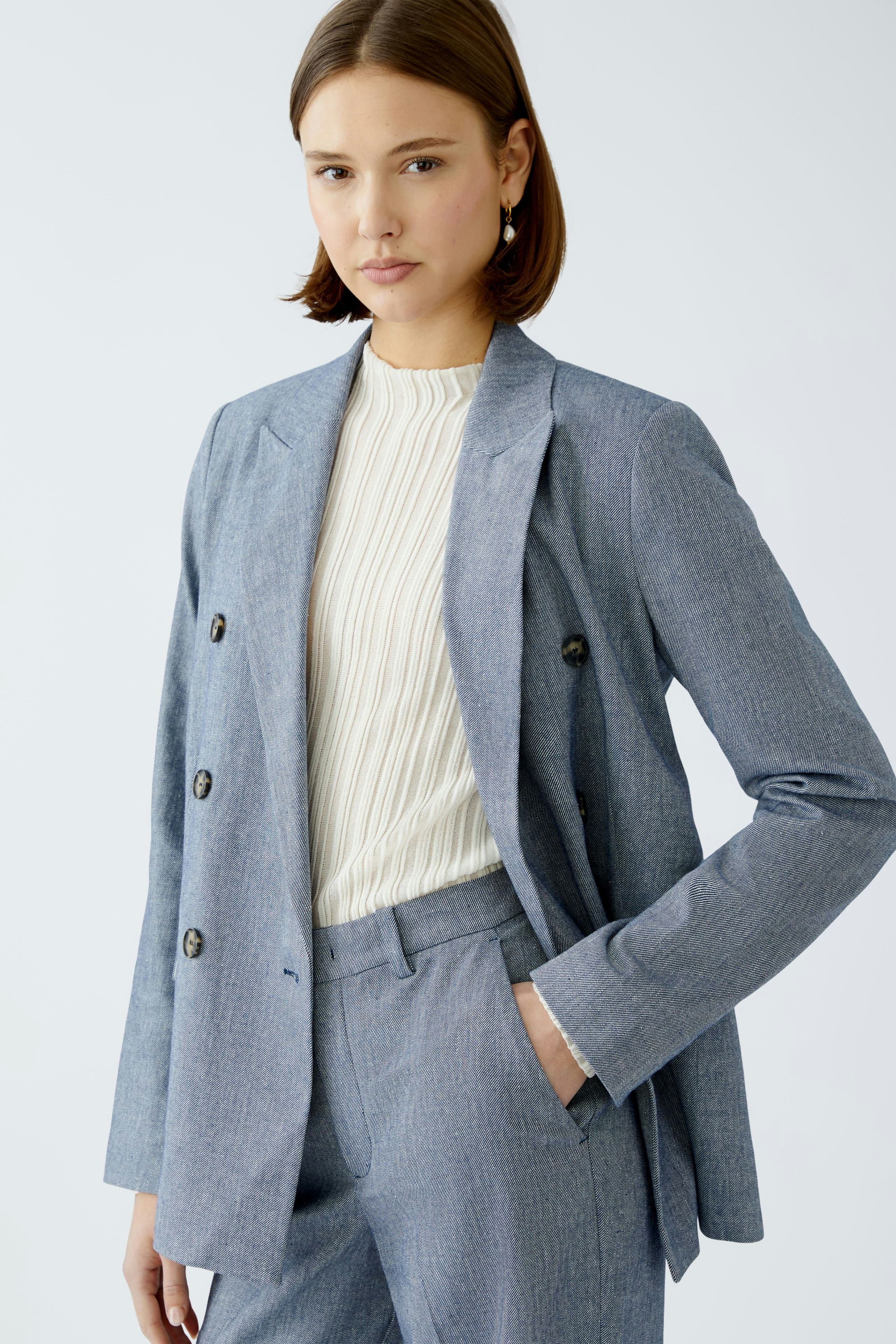 Stylish women's blazer: A woman in a light blue double-breasted blazer paired with matching trousers.