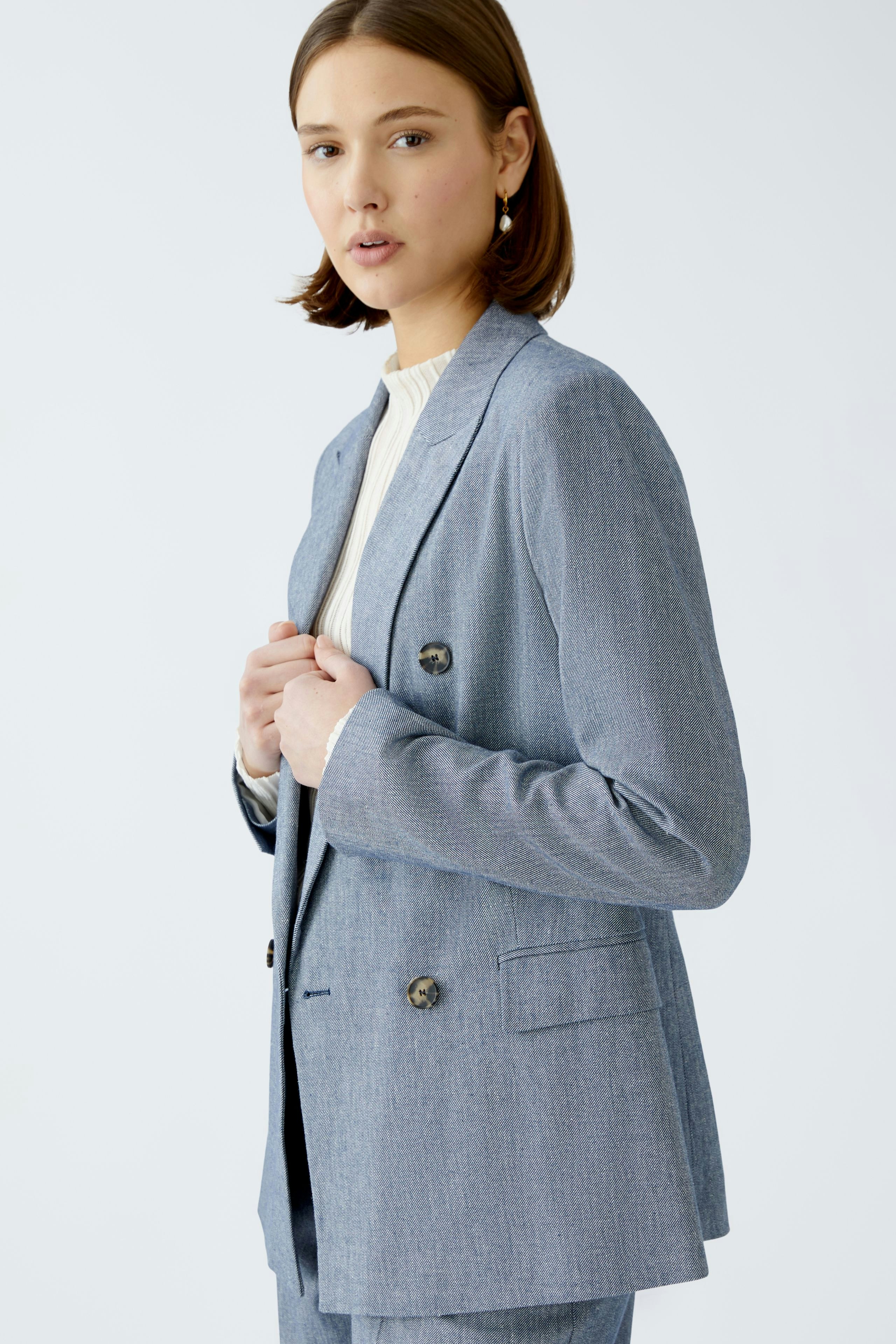 Stylish women's blazer: A woman in a light blue double-breasted blazer with a tailored fit.