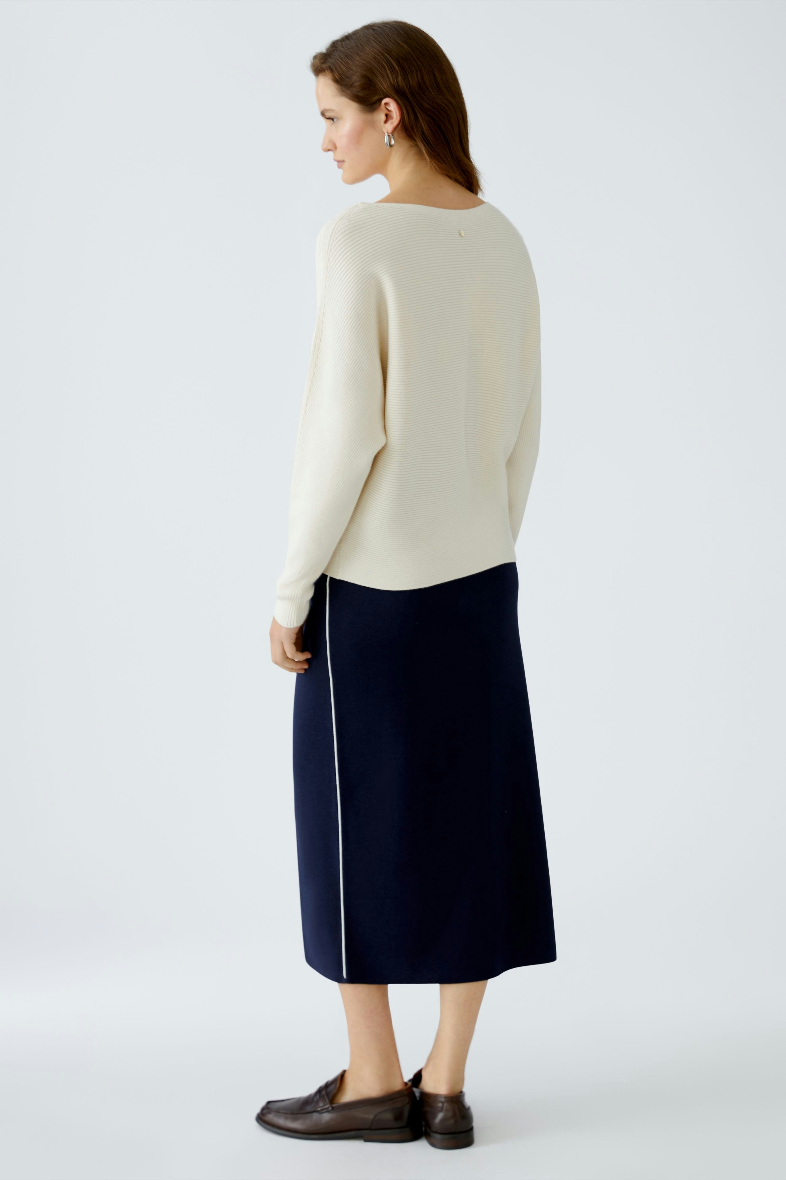 Eleganter Damen-Pullover in Creme, lässig kombiniert mit einem langen, navyfarbenen Rock.