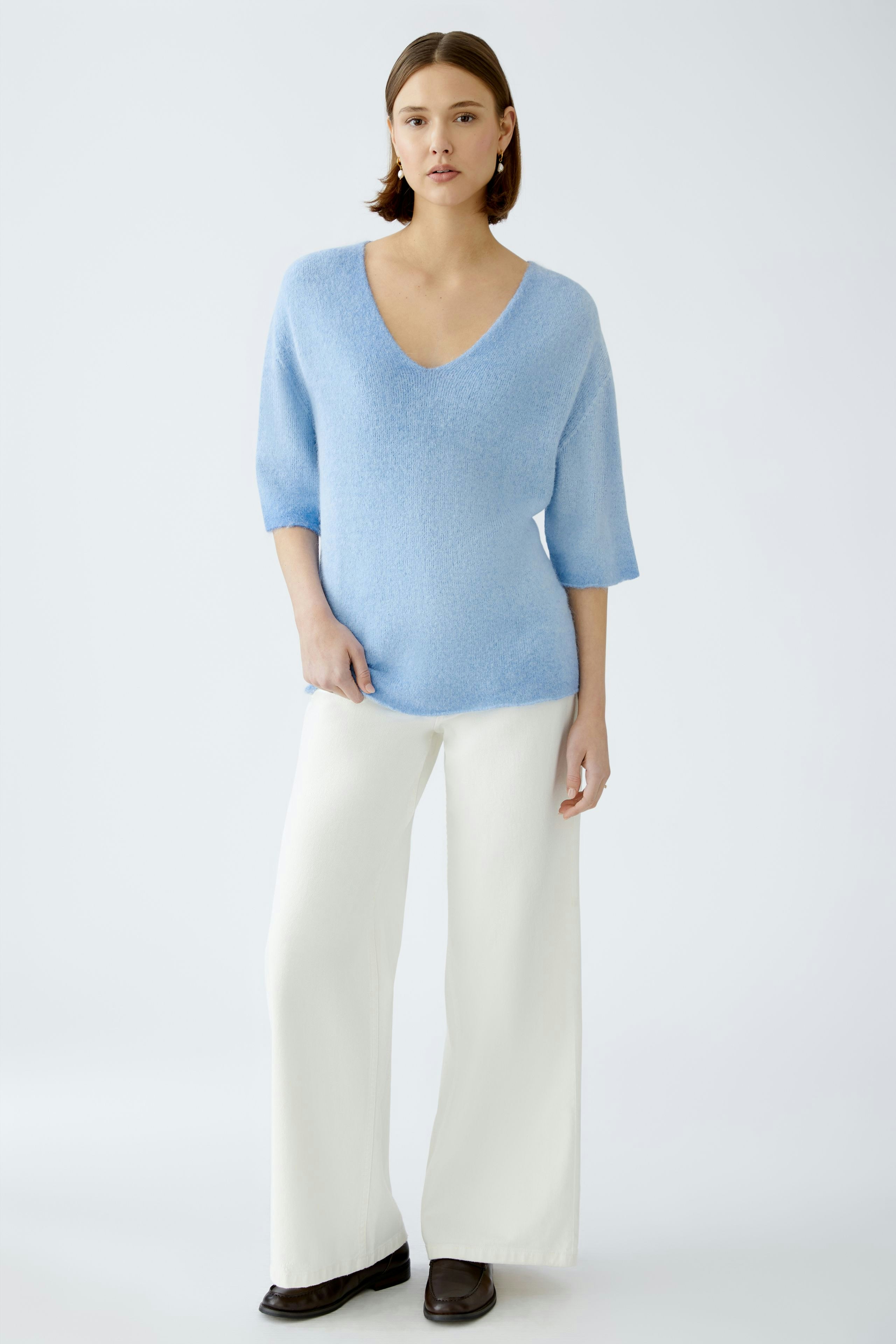Damen-Pullover: Frau in hellblauem, weichem Pullover mit V-Ausschnitt und lässiger Passform.