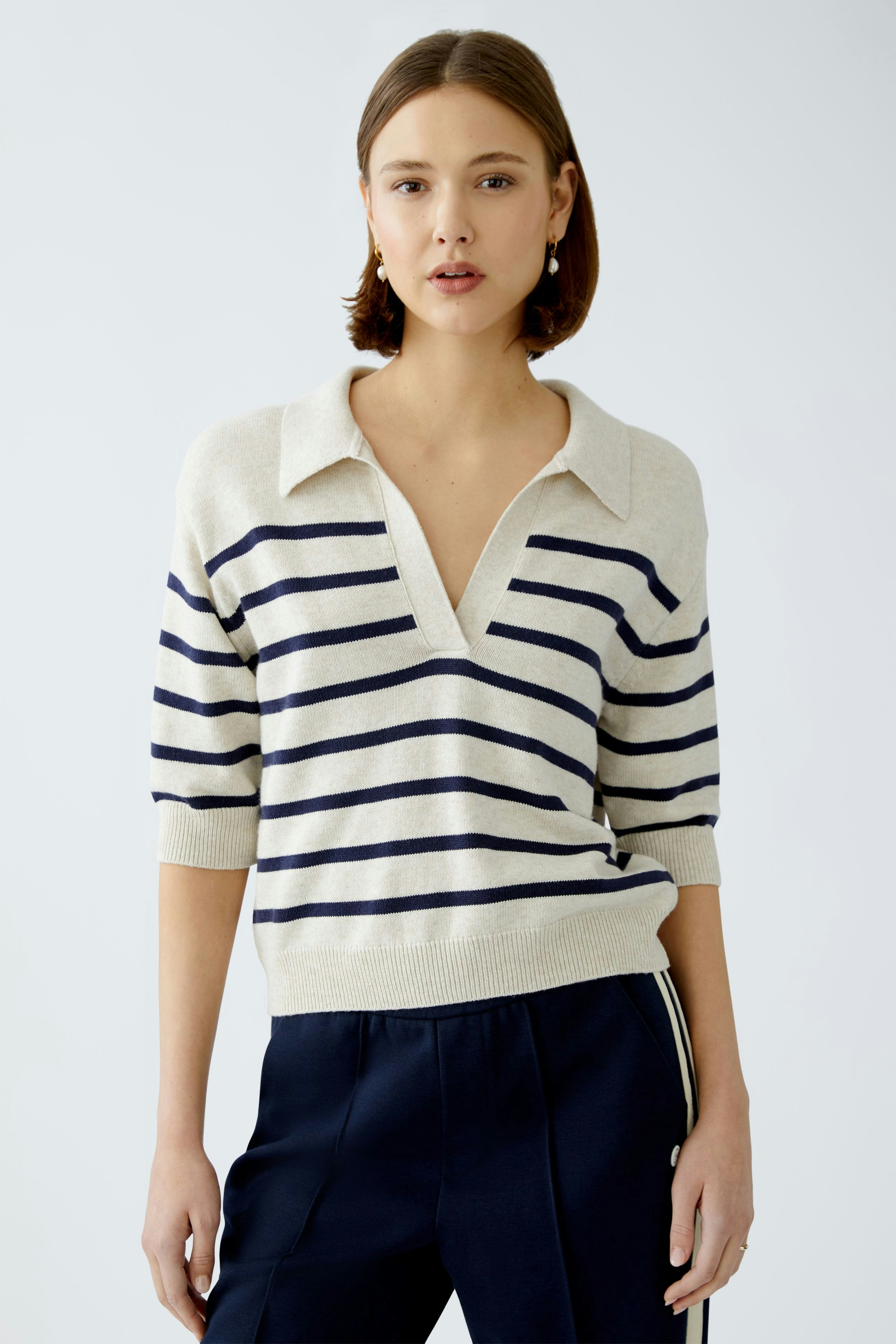 Damen-Pullover: Junge Frau in beigem, gestreiften Pullover mit Kragen und lässigem Schnitt.