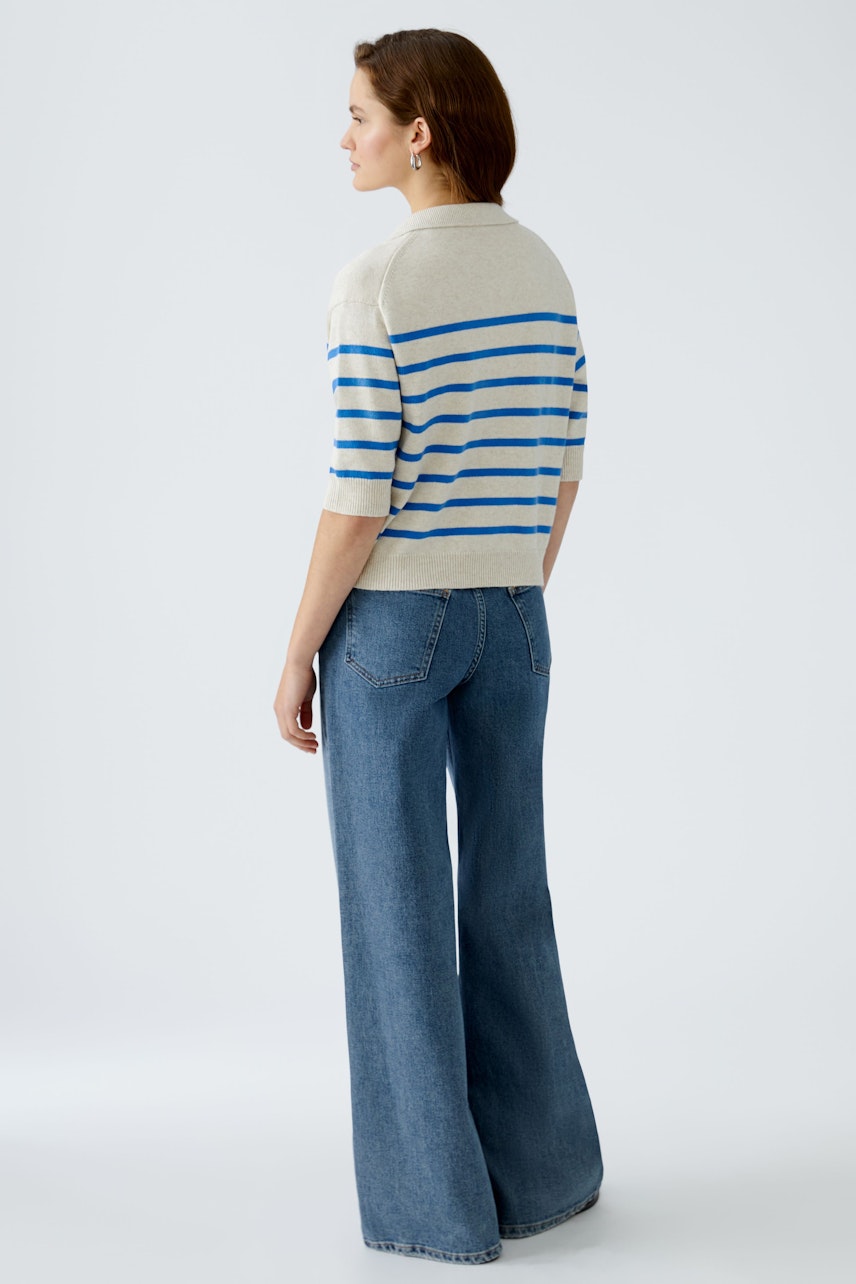 Damen-Pullover: Frau mit gestreiftem Pullover in Beige und Blau, kombiniert mit weiten Jeans.