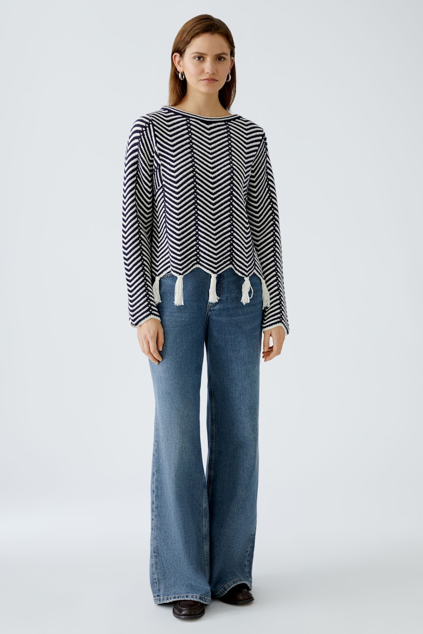 Stylish women's pullover: A woman in a navy and white chevron-patterned pullover with a relaxed fit.