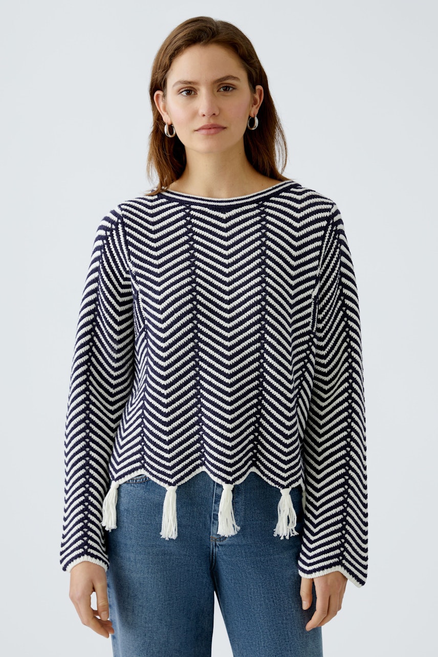 Stylish women's pullover: A woman in a navy and white striped pullover with tassels.