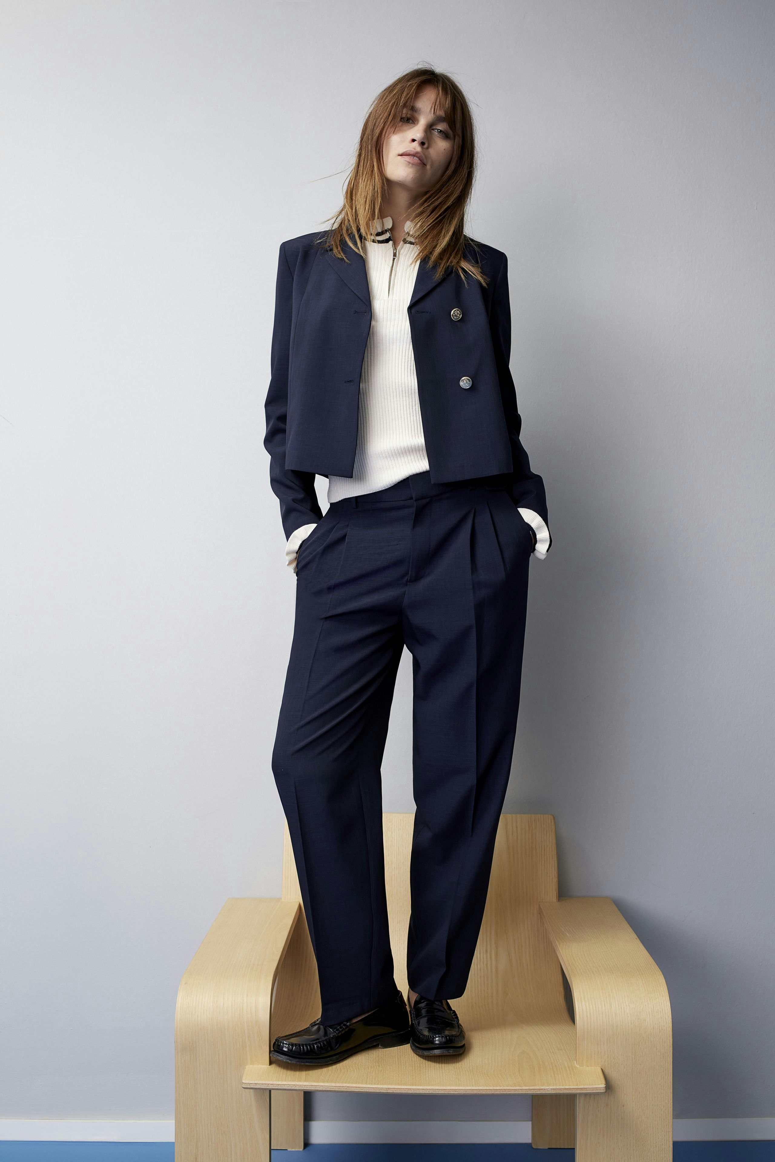 Eleganter Damen-Pullover: Frau in schickem, navyfarbenem Pullover mit modernem Schnitt und lässiger Hose.