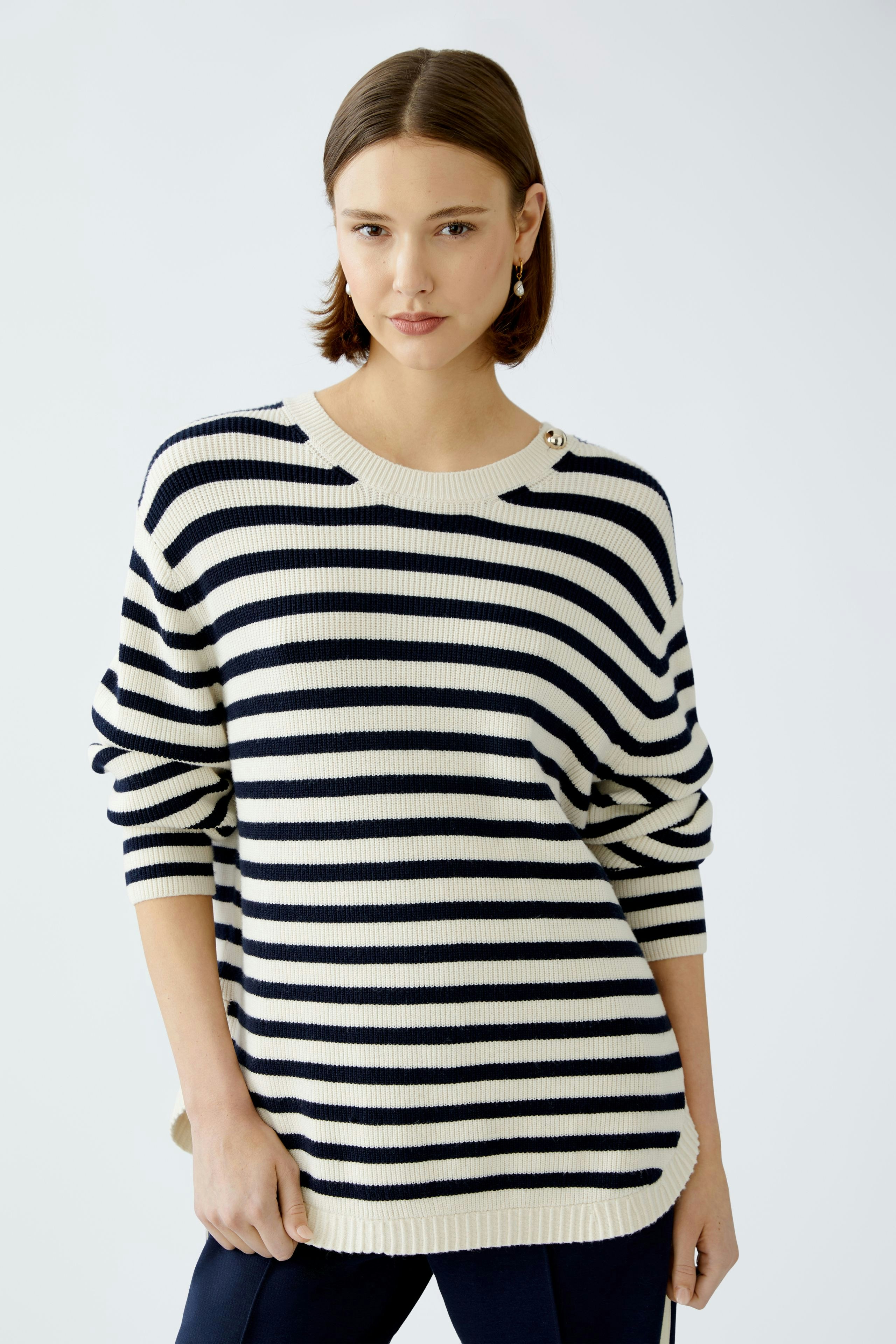 Damen-Pullover: Junge Frau im gestreiften Pullover mit maritimen Farben und lässigem Schnitt.