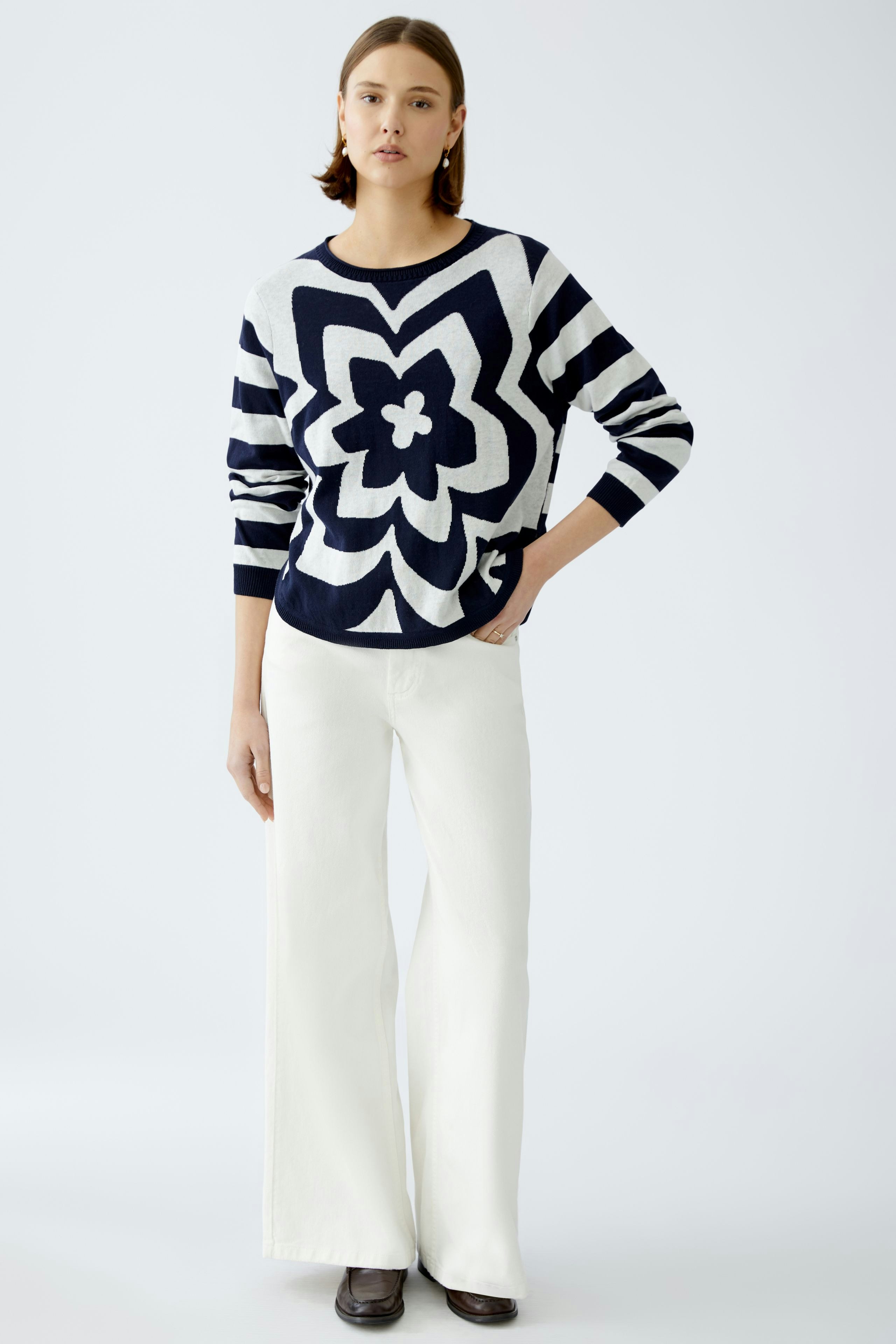 Stylish women's pullover: A woman in a navy and white patterned pullover stands confidently.