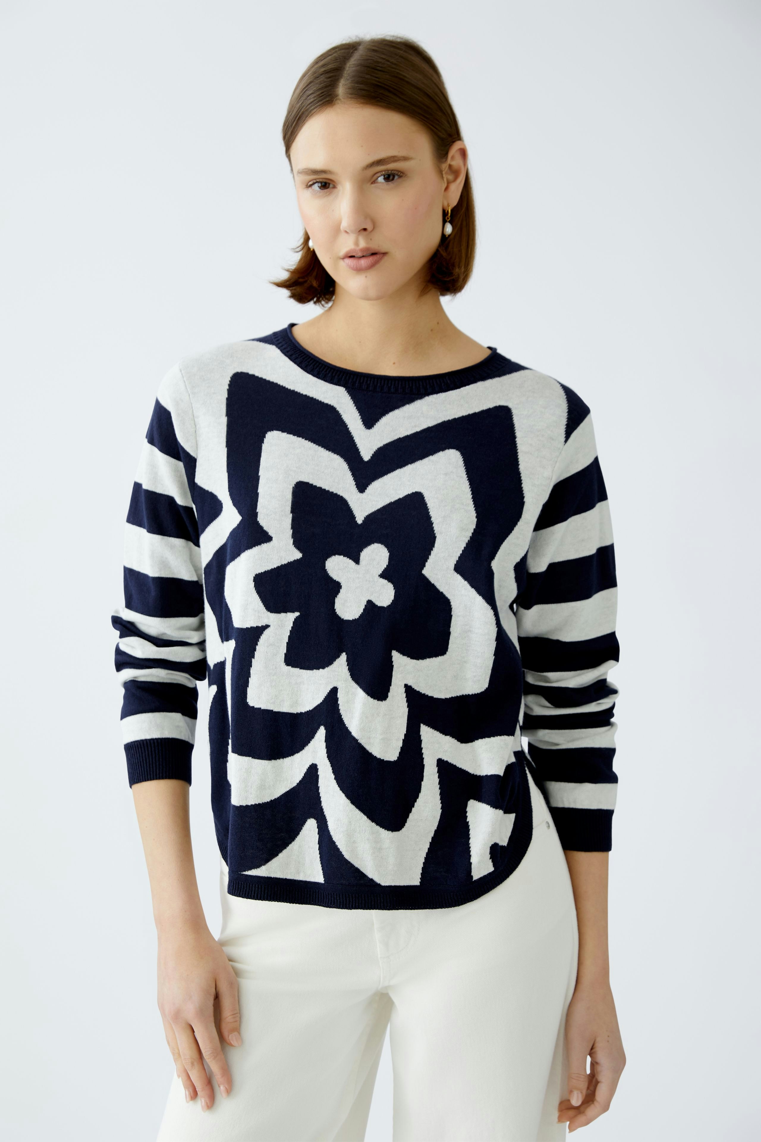 Stylish women's pullover: A woman in a navy and white patterned pullover with stripes.