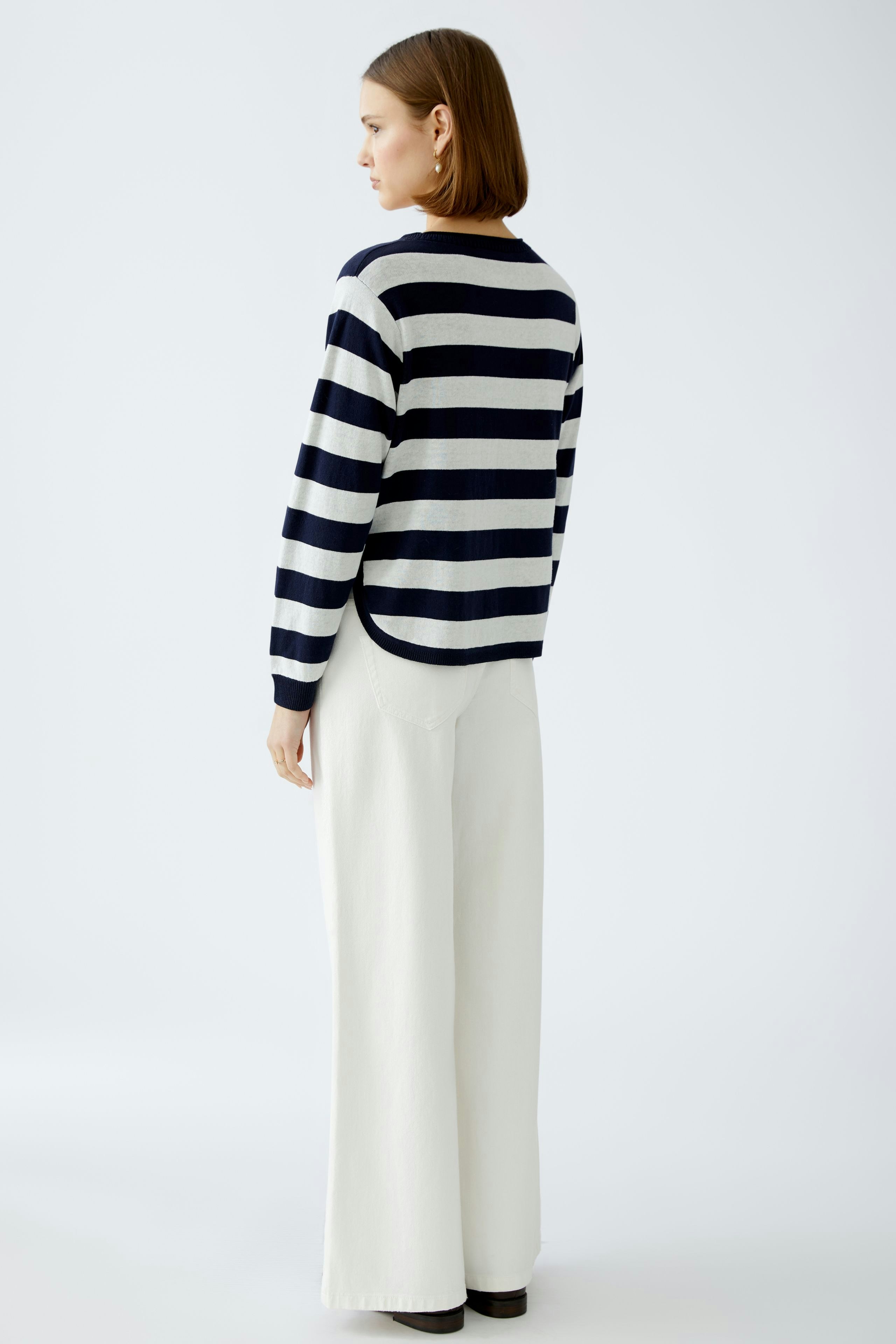 Stylish women's pullover: A woman in a striped pullover with a relaxed fit, paired with wide-leg pants.