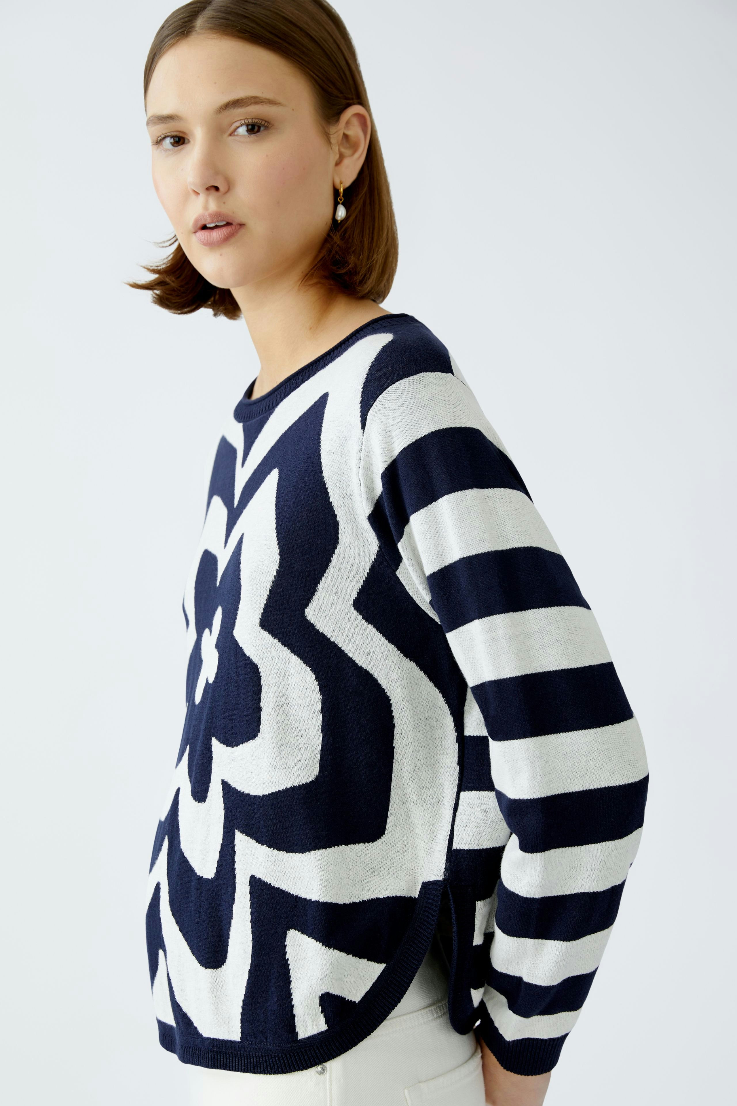 Stylish women's pullover: A woman in a navy and white striped pullover with floral design.