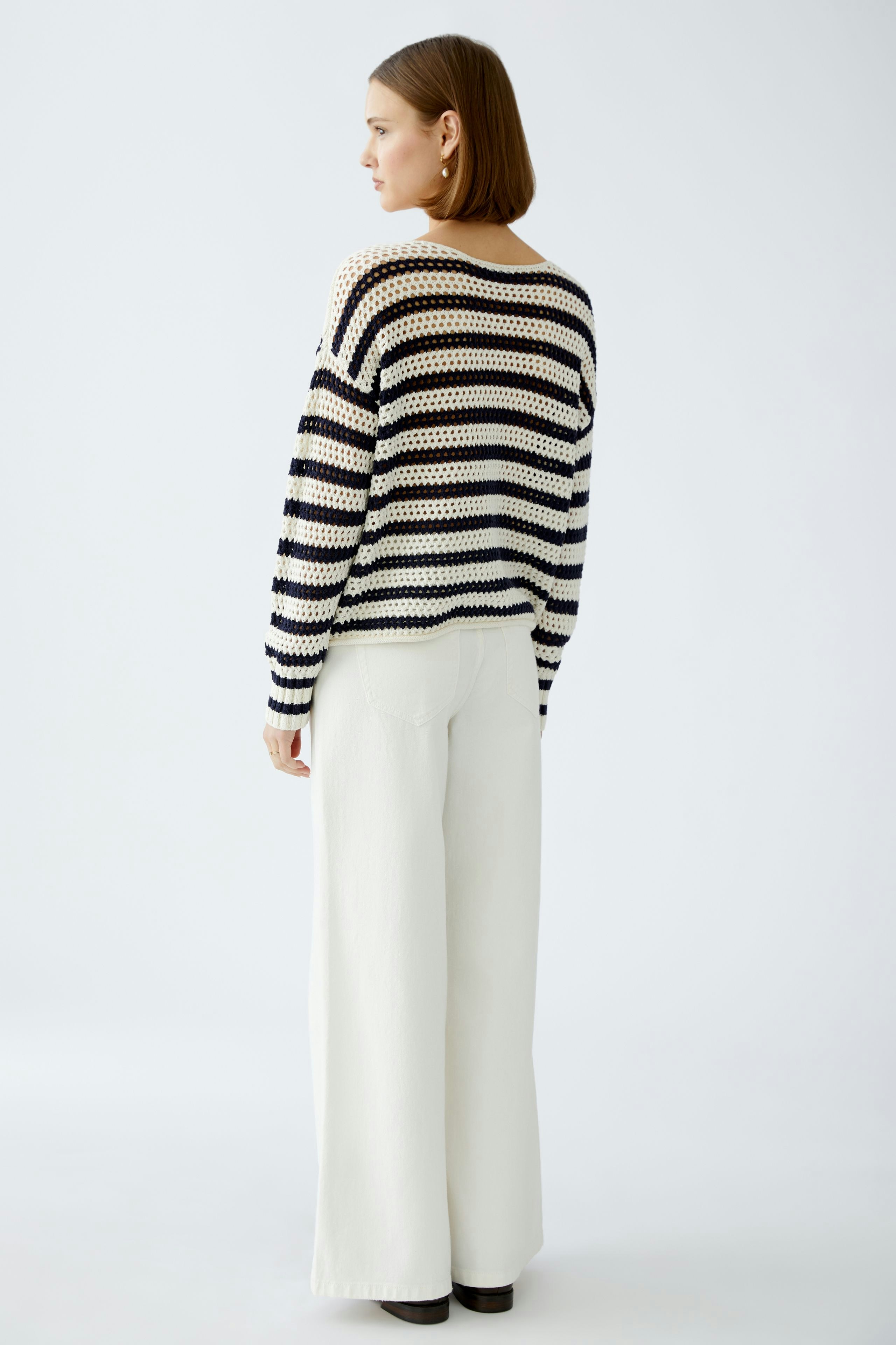 Stylish women's pullover: A woman in a striped pullover with wide sleeves and relaxed fit.