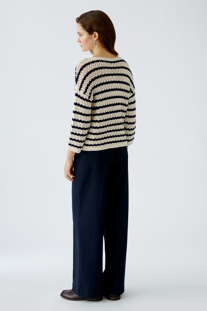 Damen-Pullover: Frau in gestreiftem Strickpullover mit lässigem Schnitt und eleganten Hosen.