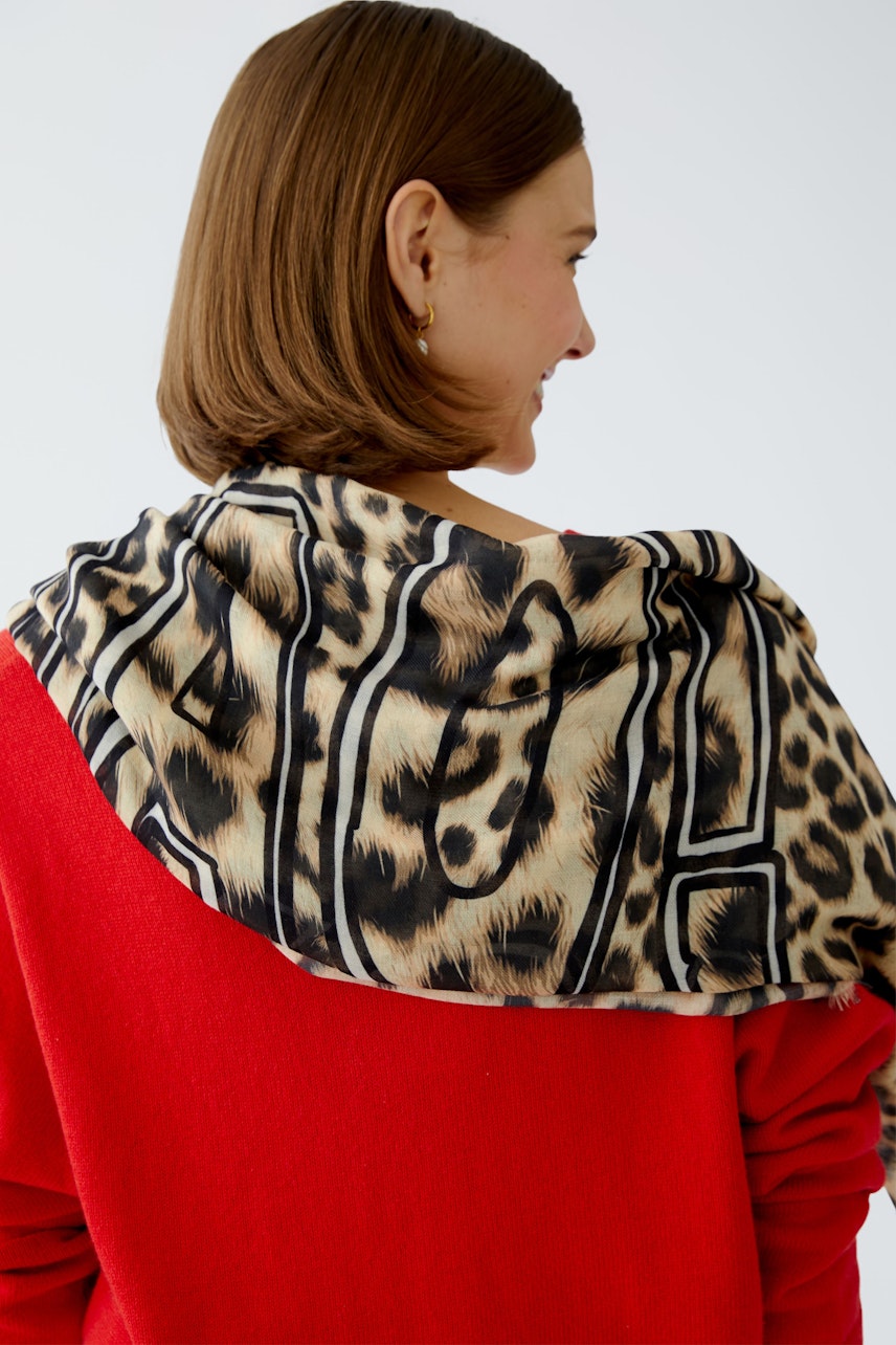 Stylish women's scarf with a leopard print, elegantly draped over the shoulder.