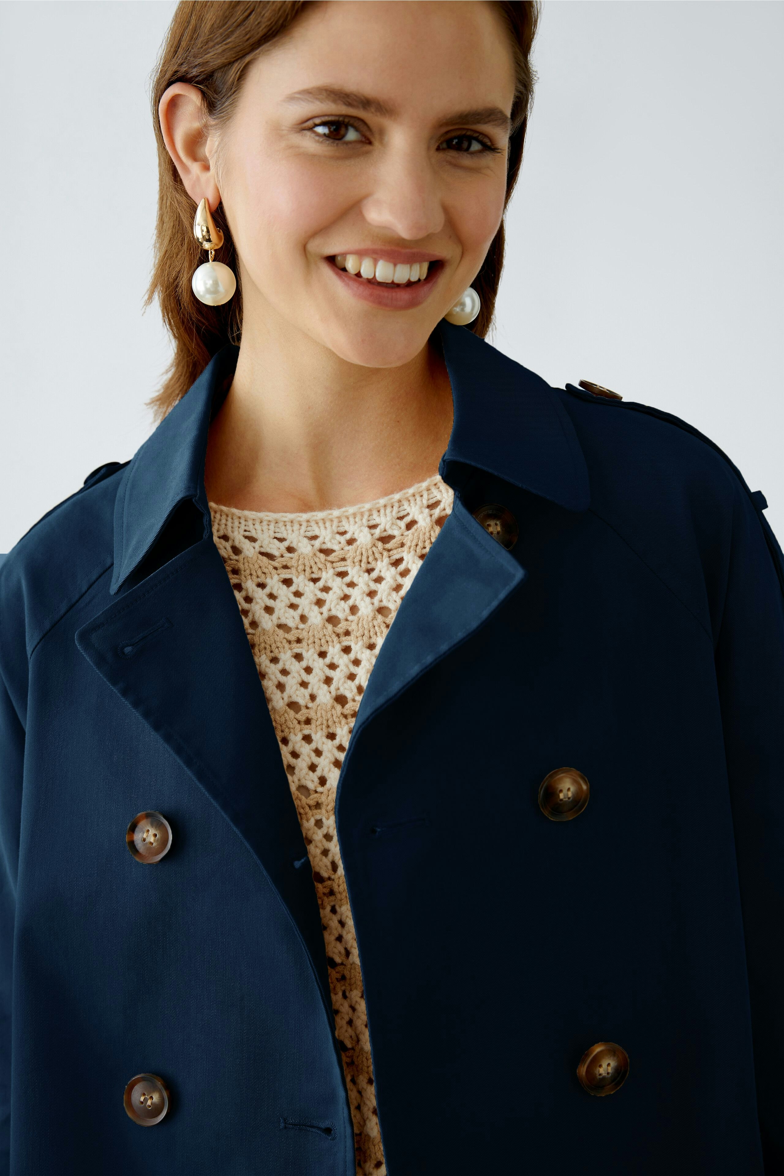 Stylish women's outdoor jacket: A woman smiles confidently in a navy blue coat, perfect for any adventure.