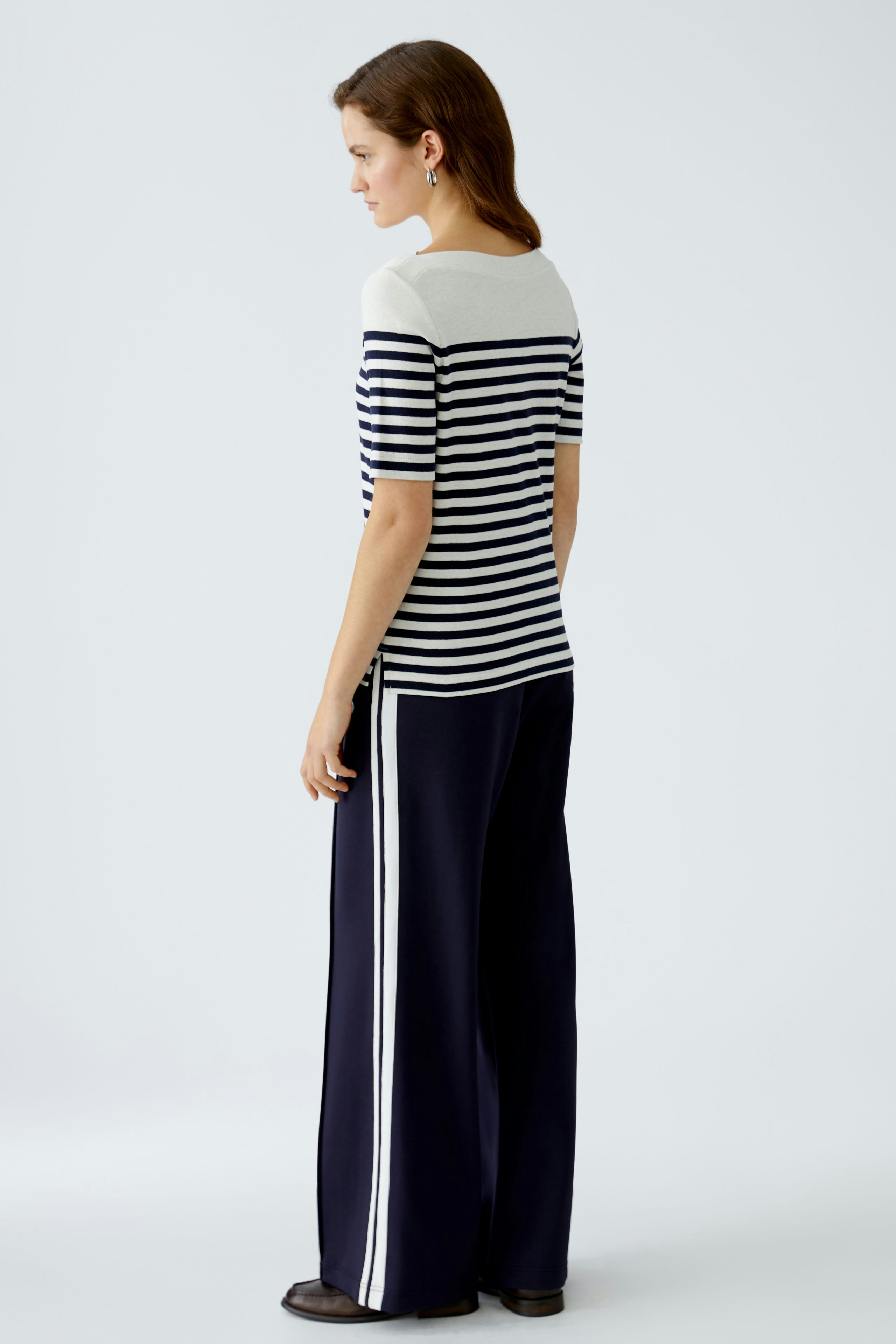 Damen Langarmshirt: Frau in gestreiftem Shirt mit lässigem Schnitt und eleganten Hosen.