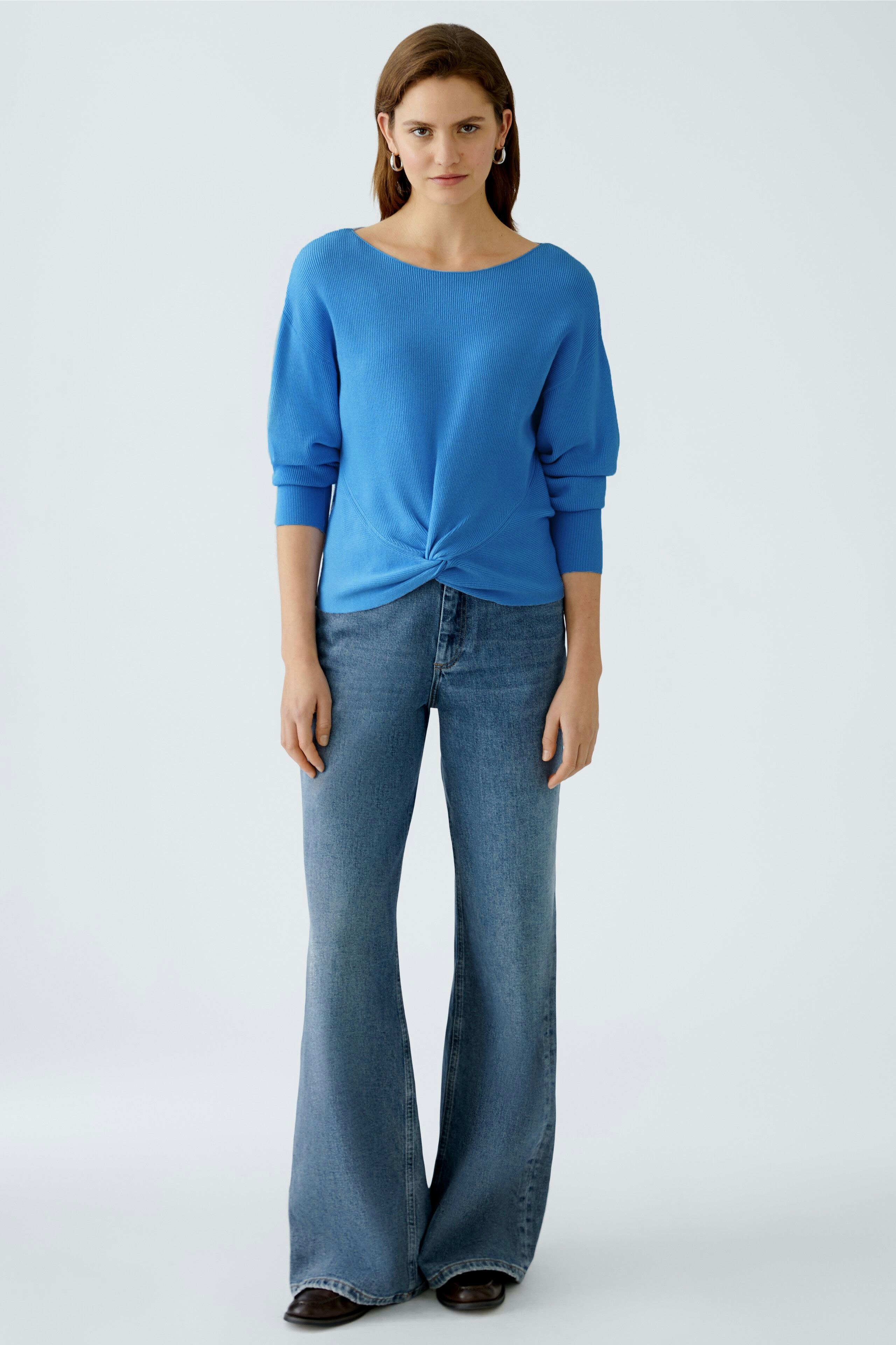 Damen-Pullover in Blau: Frau trägt einen lässigen, knotenförmigen Pullover mit 3/4-Ärmeln.