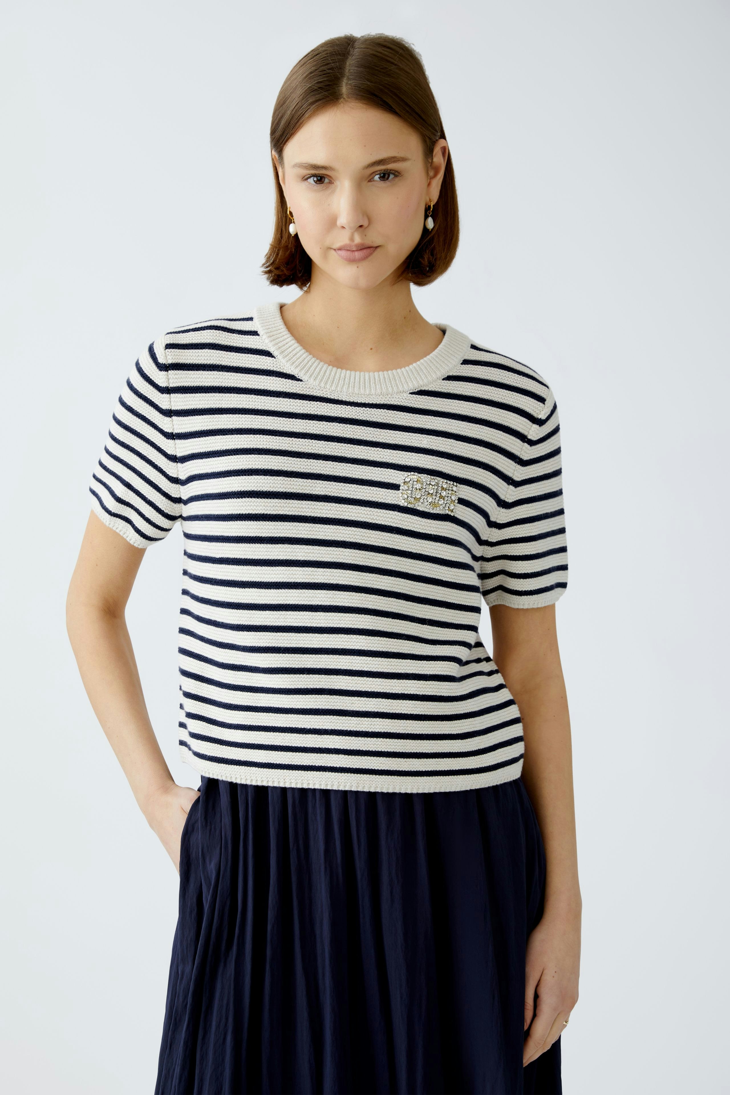 Stylish women's pullover: A woman in a striped short-sleeve pullover with a chic design.