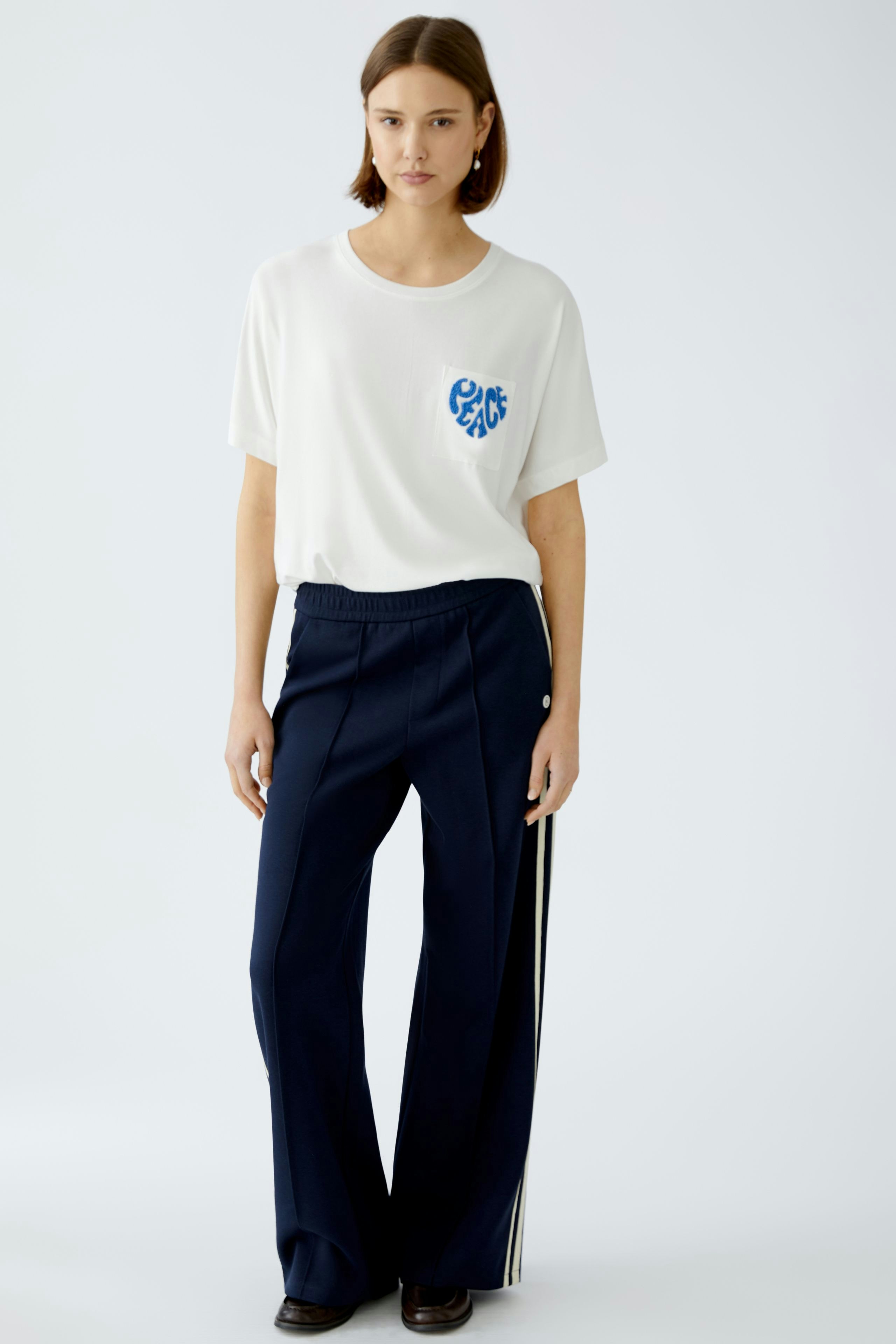 Damen-T-Shirt in Weiß mit blauem Peace-Print, lässig und modern, ideal für den Alltag.