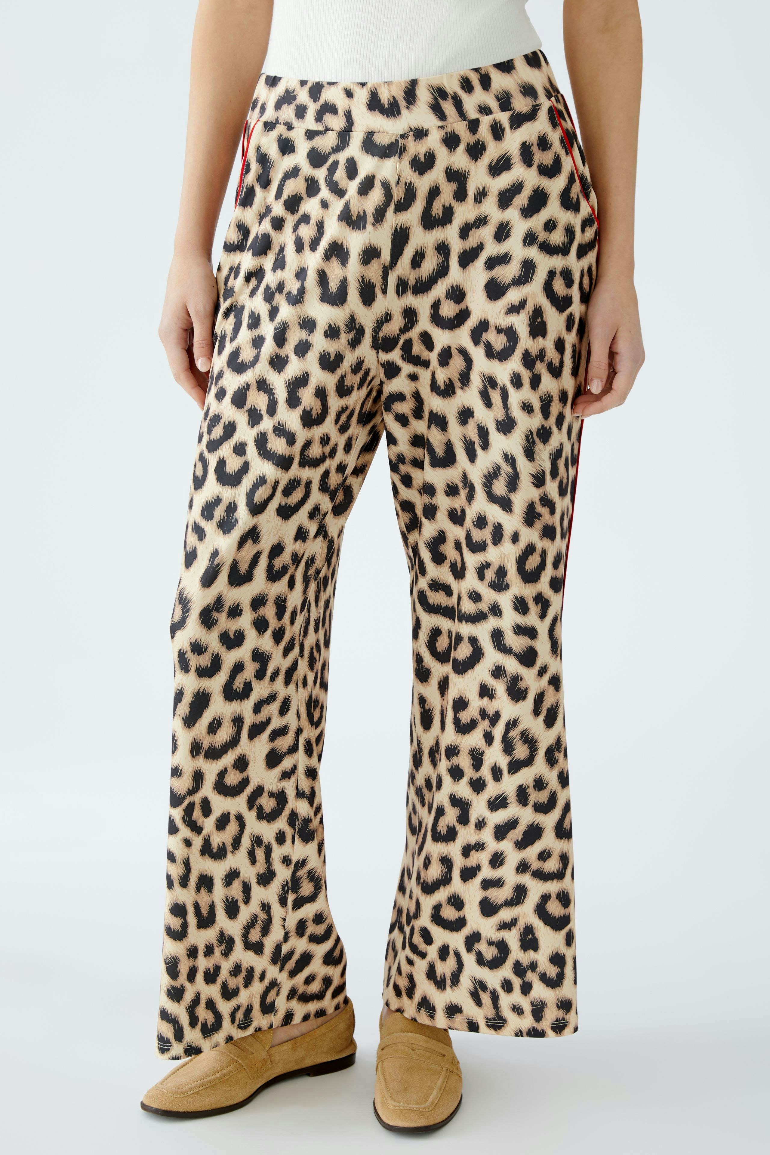 Stylish women's pants: A woman in leopard print trousers with a relaxed fit, perfect for casual outings.