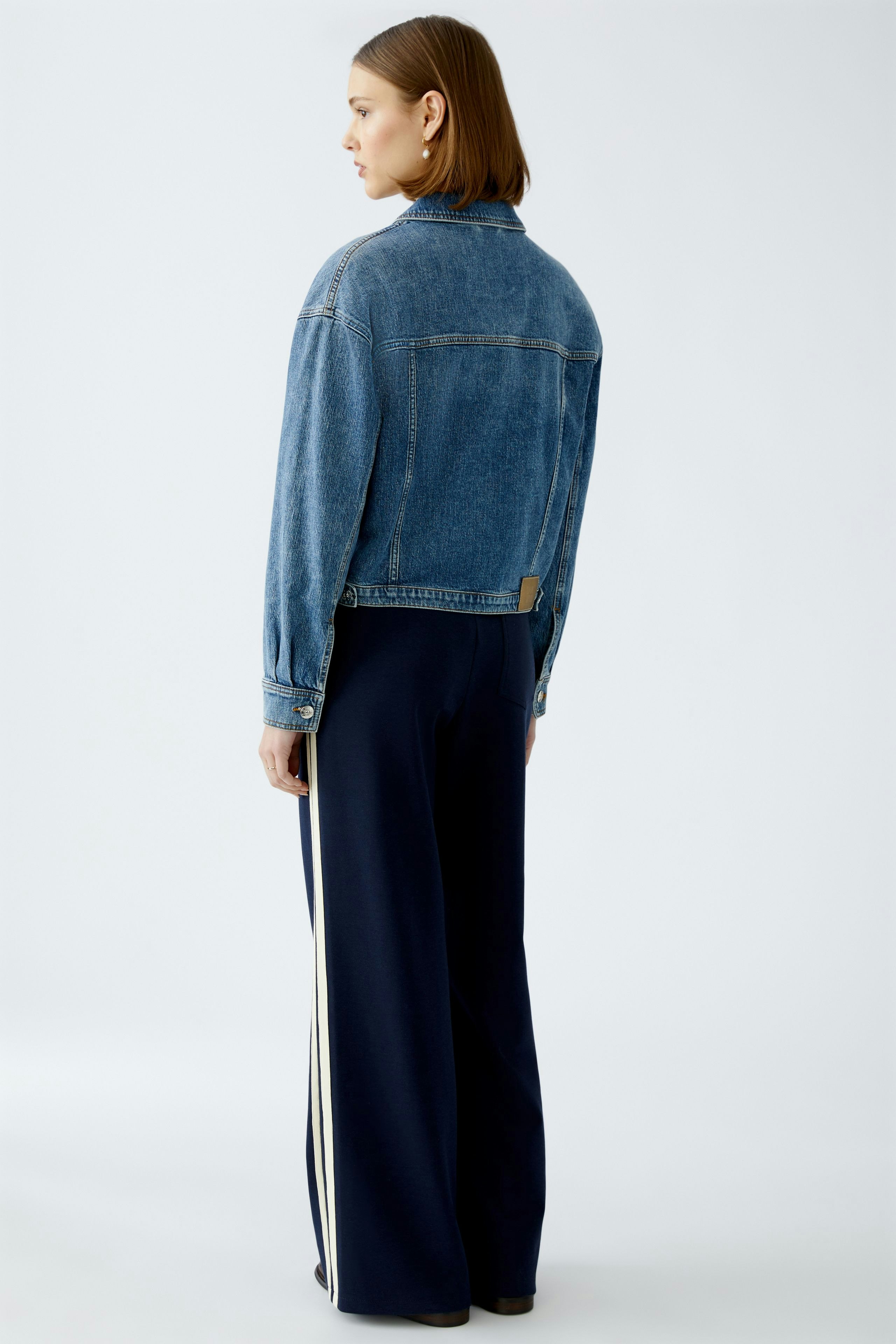 Stylish women's denim jacket: A woman in a classic blue jeans jacket, showcasing a casual yet chic look.