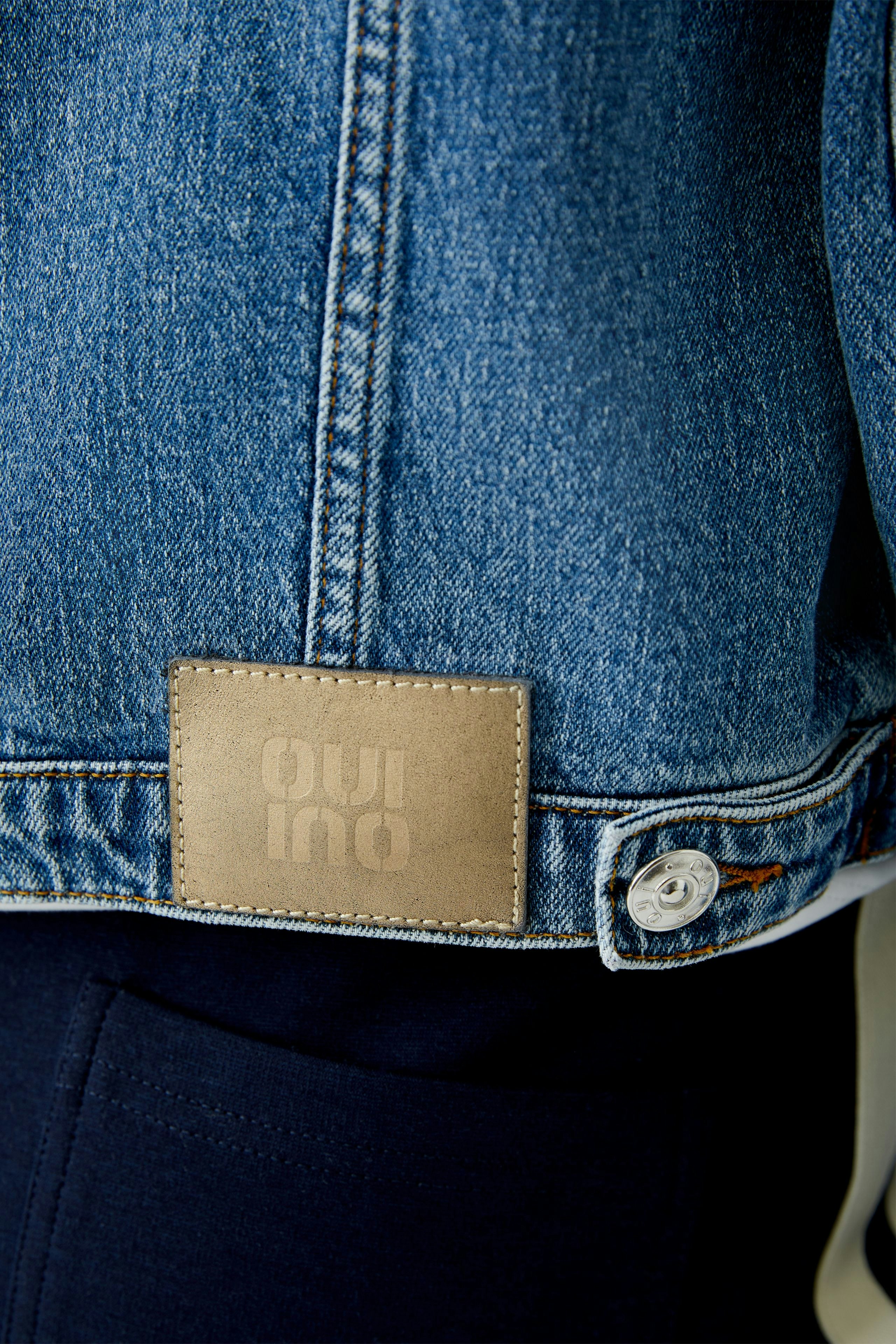 Stylish women's denim jacket with a classic cut and logo detail on the back.
