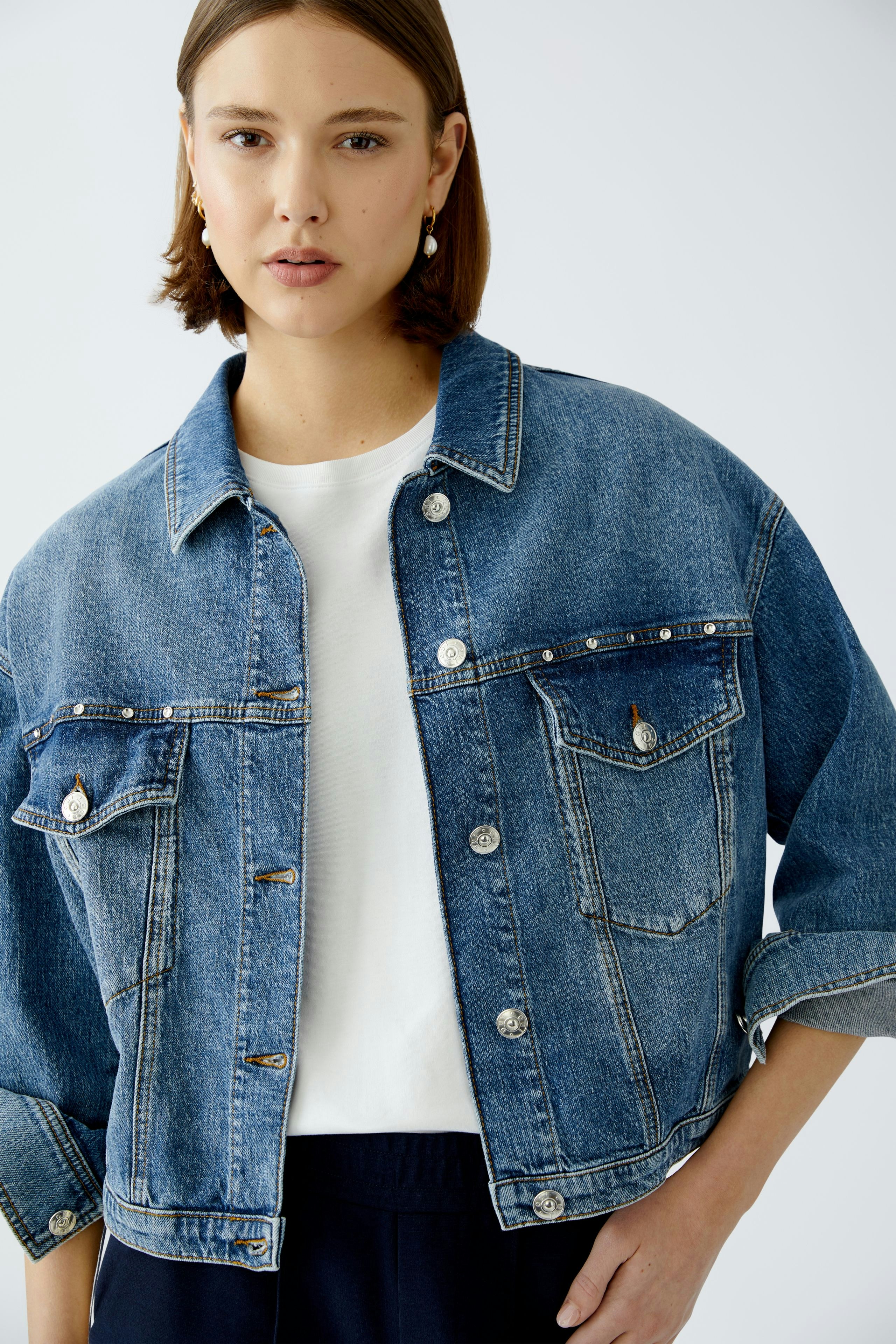 Stylish women's denim jacket: A woman in a blue denim jacket with a relaxed fit and classic design.