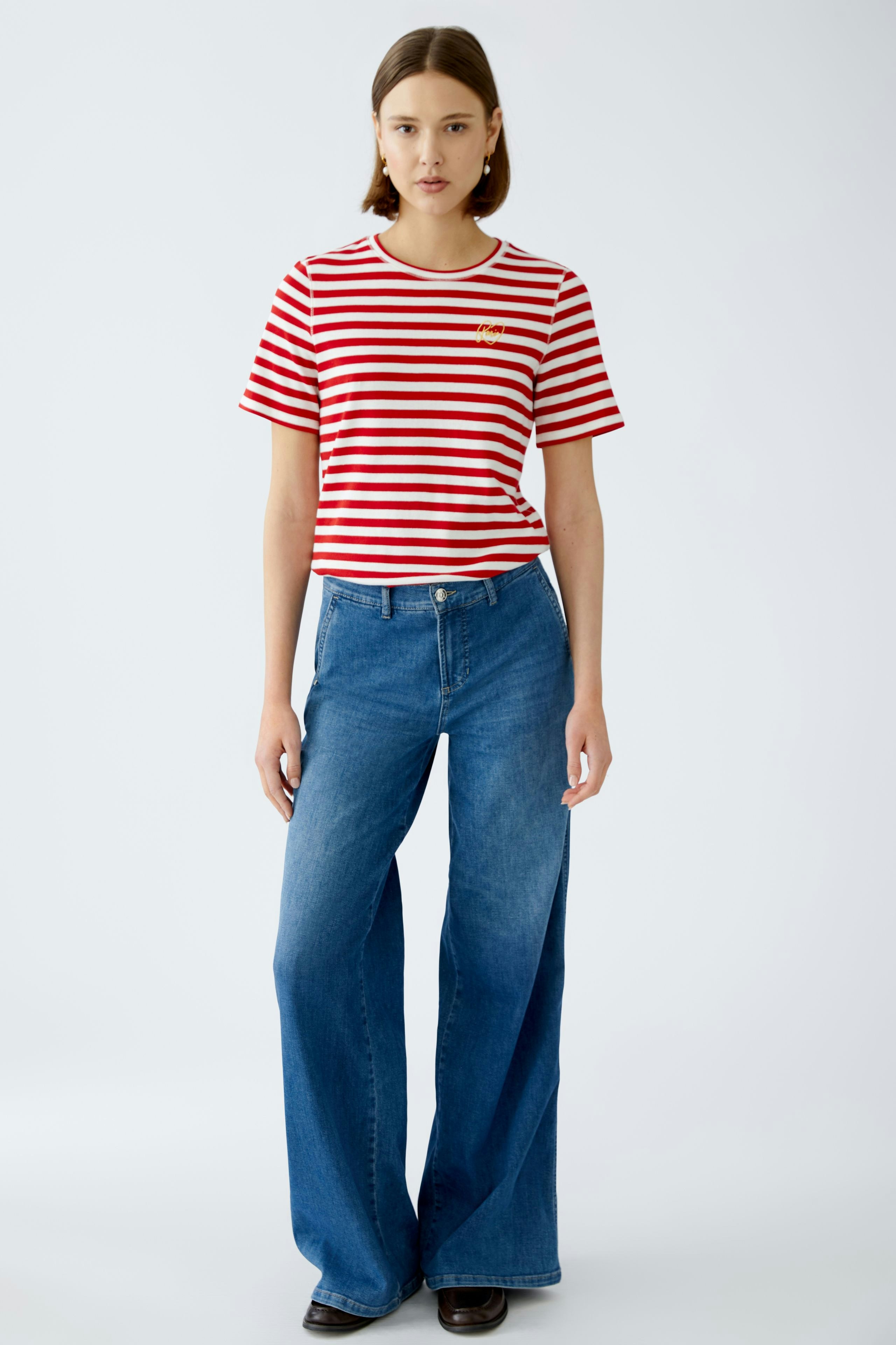 Stylish women's T-shirt: A woman in a red and white striped tee paired with flared jeans.