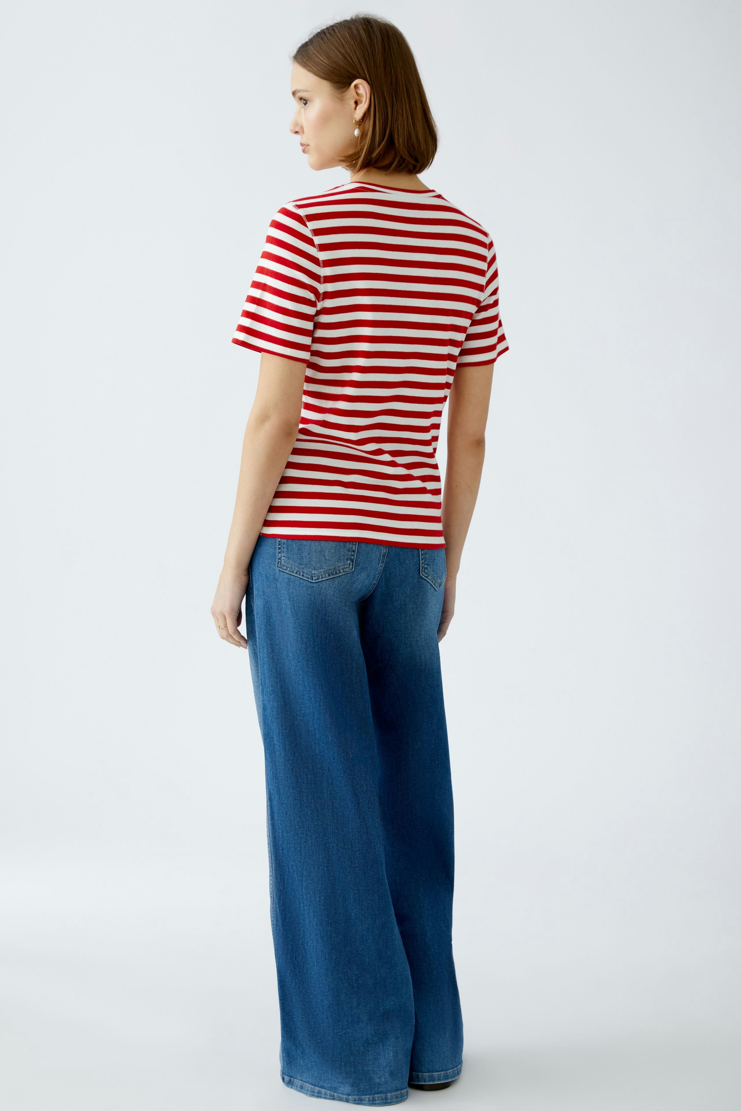Stylish women's T-shirt: A woman in a red and white striped tee paired with wide-leg jeans.