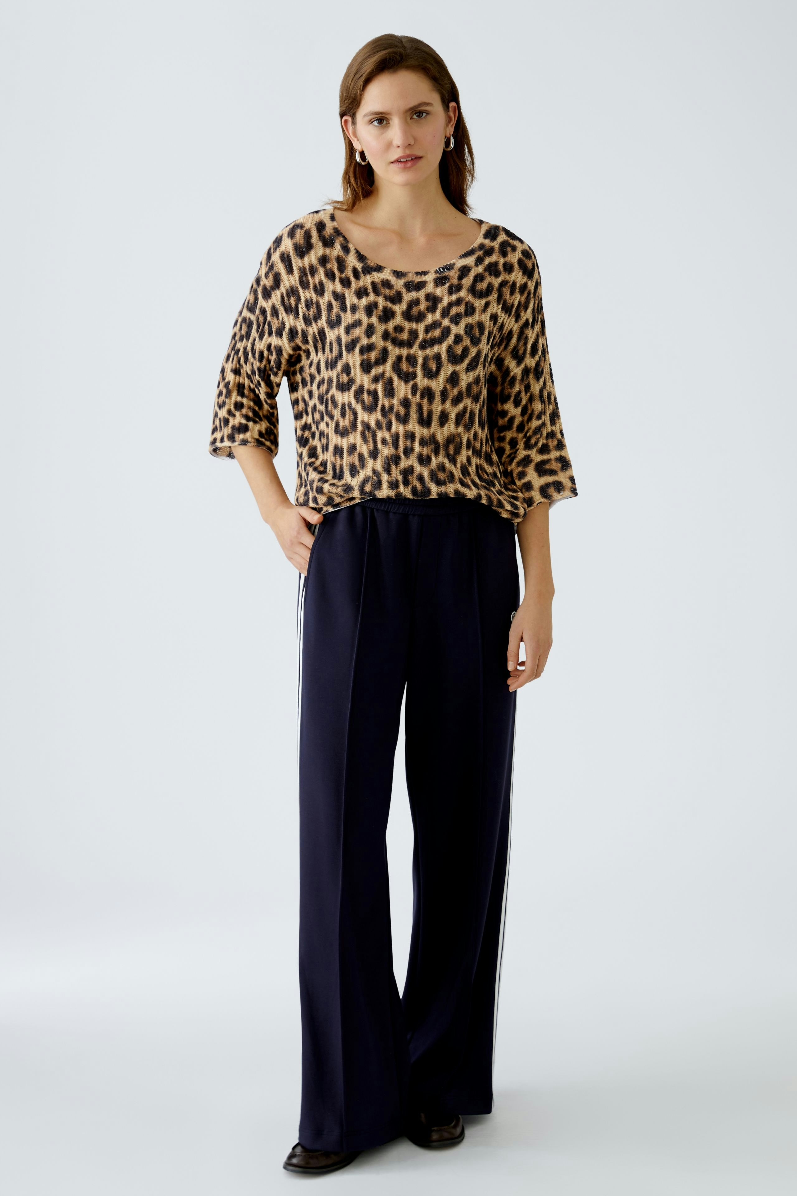 Stylish women's pullover: A woman in a leopard print pullover paired with wide-leg trousers.