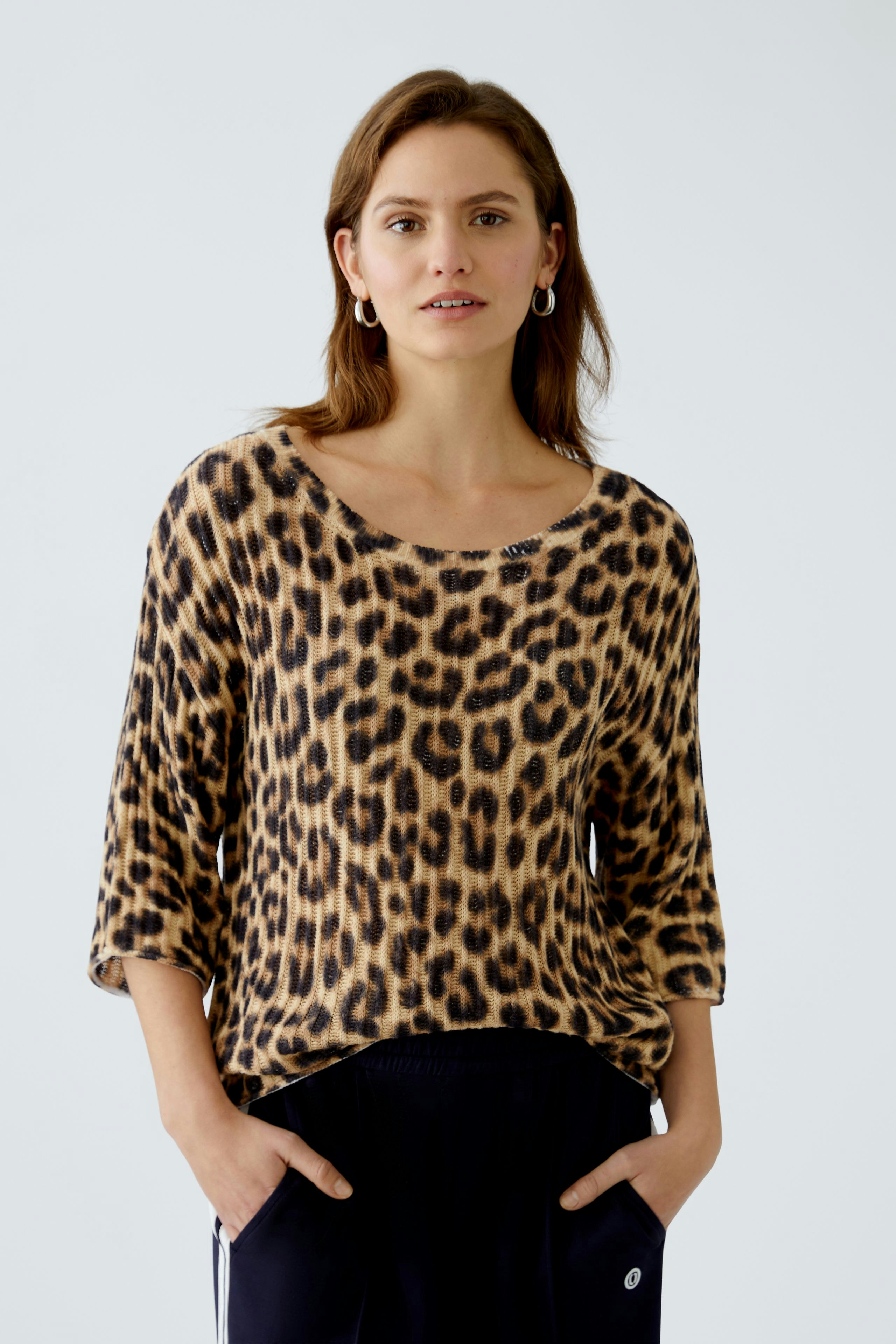 Stylish women's pullover: A woman in a leopard print pullover with a relaxed fit.