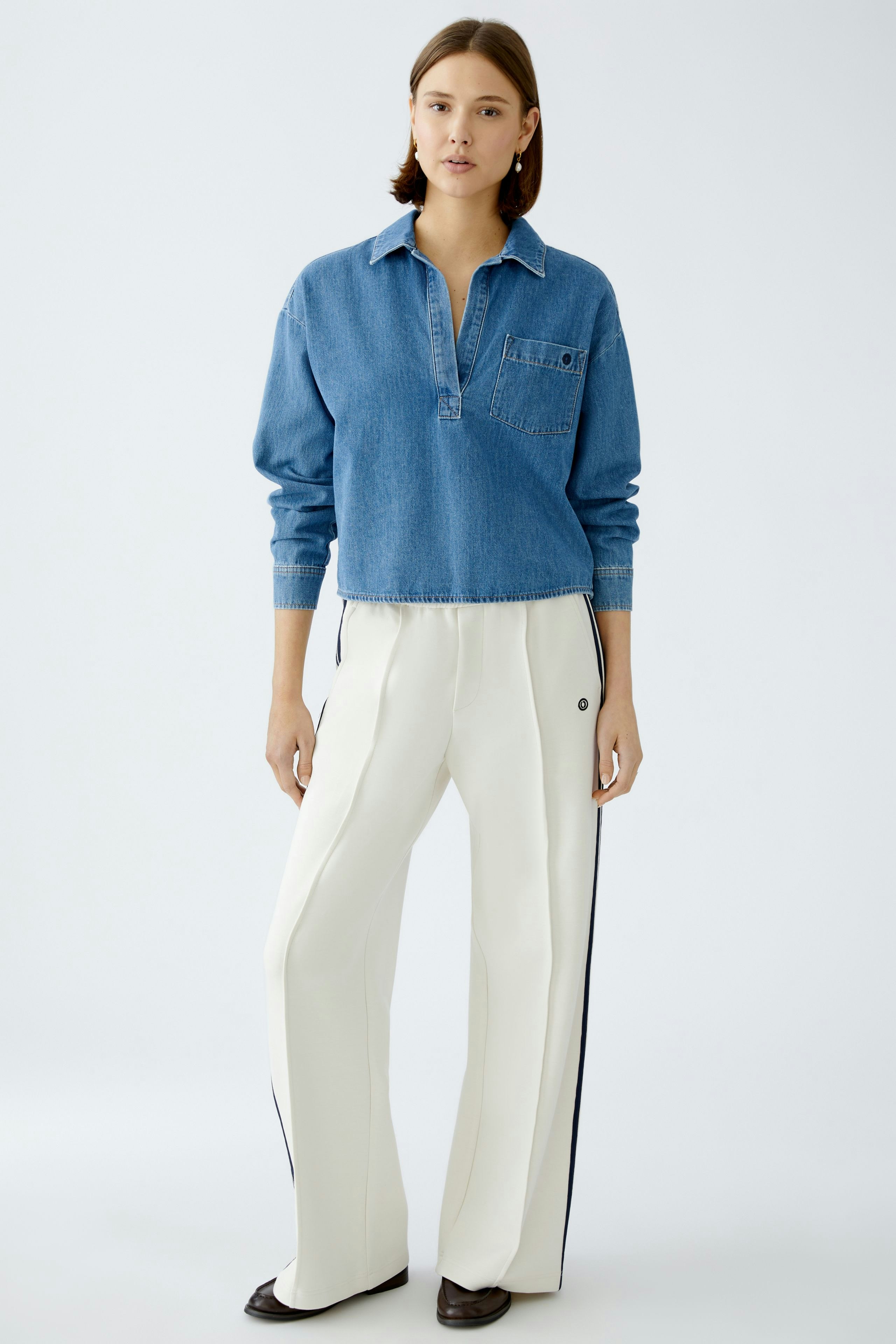 Damen-Jeanshemd: Junge Frau in lässigem, blauen Jeanshemd mit Knopfleiste und Brusttasche.