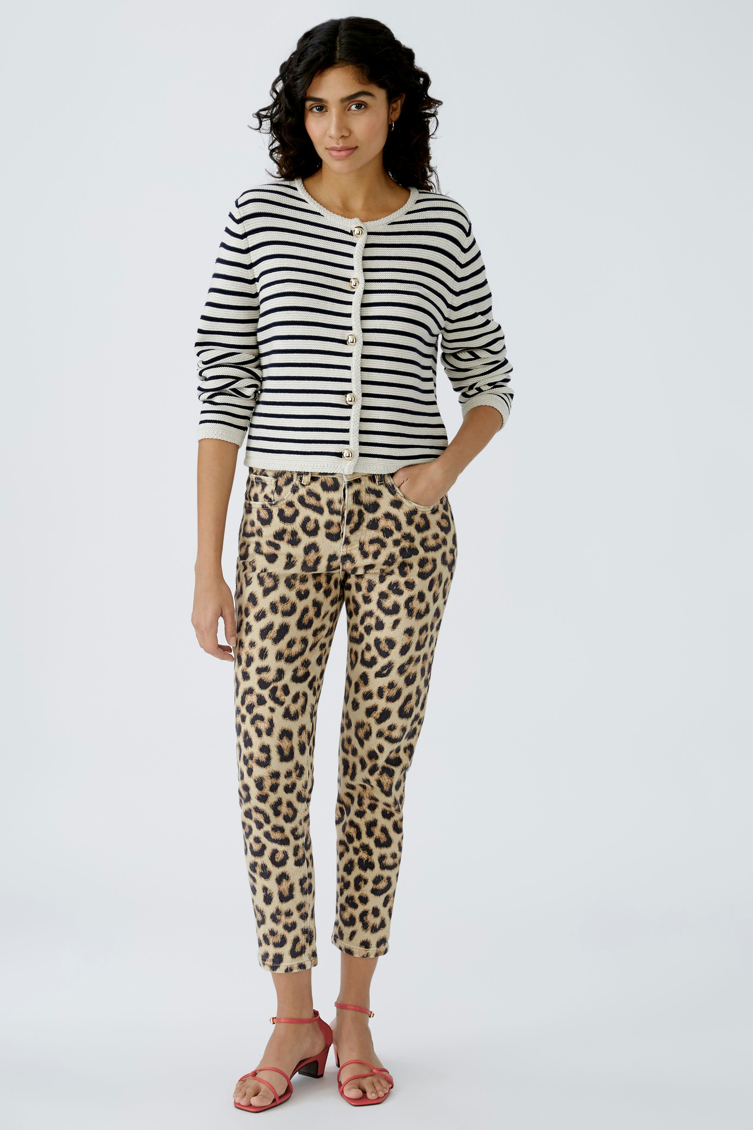 Damen-Strickjacke: Frau in gestreifter Strickjacke mit Knöpfen und lässigen Hosen im Leopardenmuster.