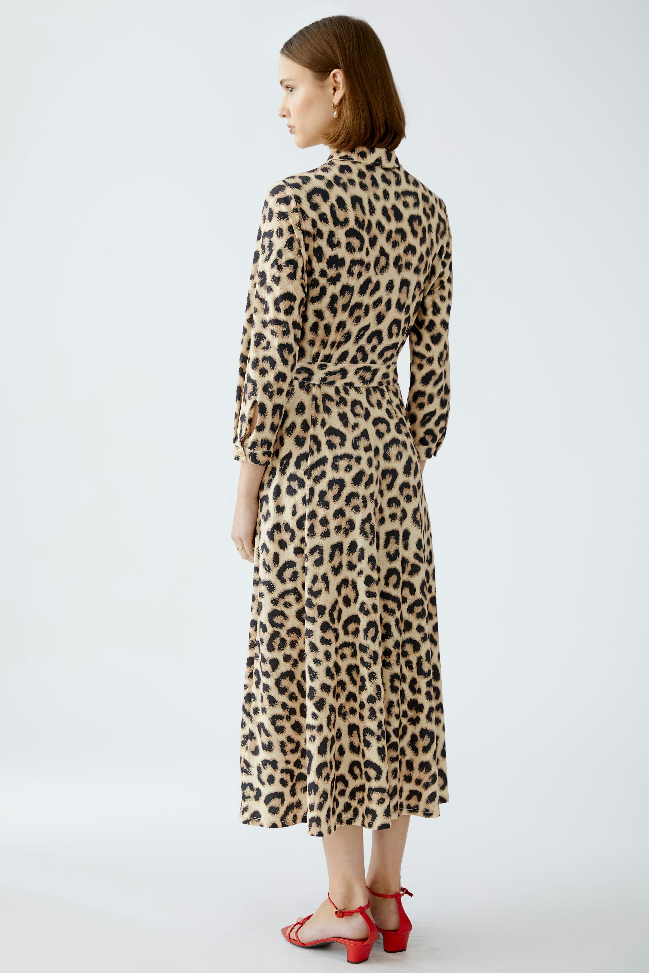 Elegant shirt dress: Woman in a stylish leopard print dress, showcasing a chic and modern design.