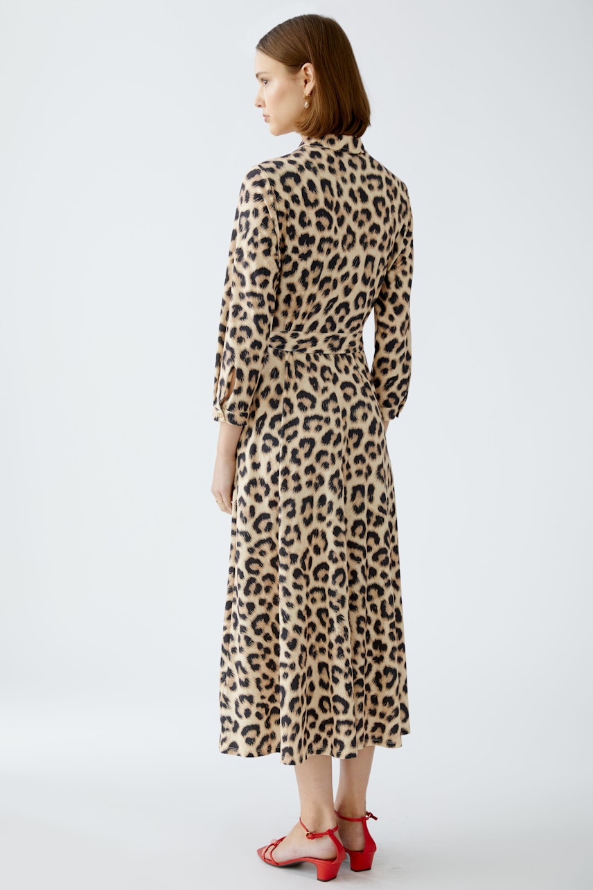 Elegant shirt dress: Woman in a stylish leopard print dress, showcasing a chic and modern design.