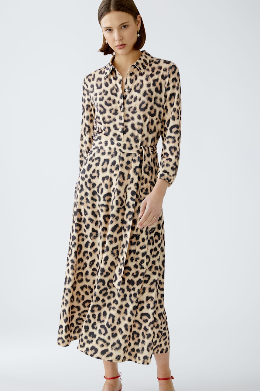 Chic shirt dress: A woman in a leopard print shirt dress with a belted waist, exuding effortless style.