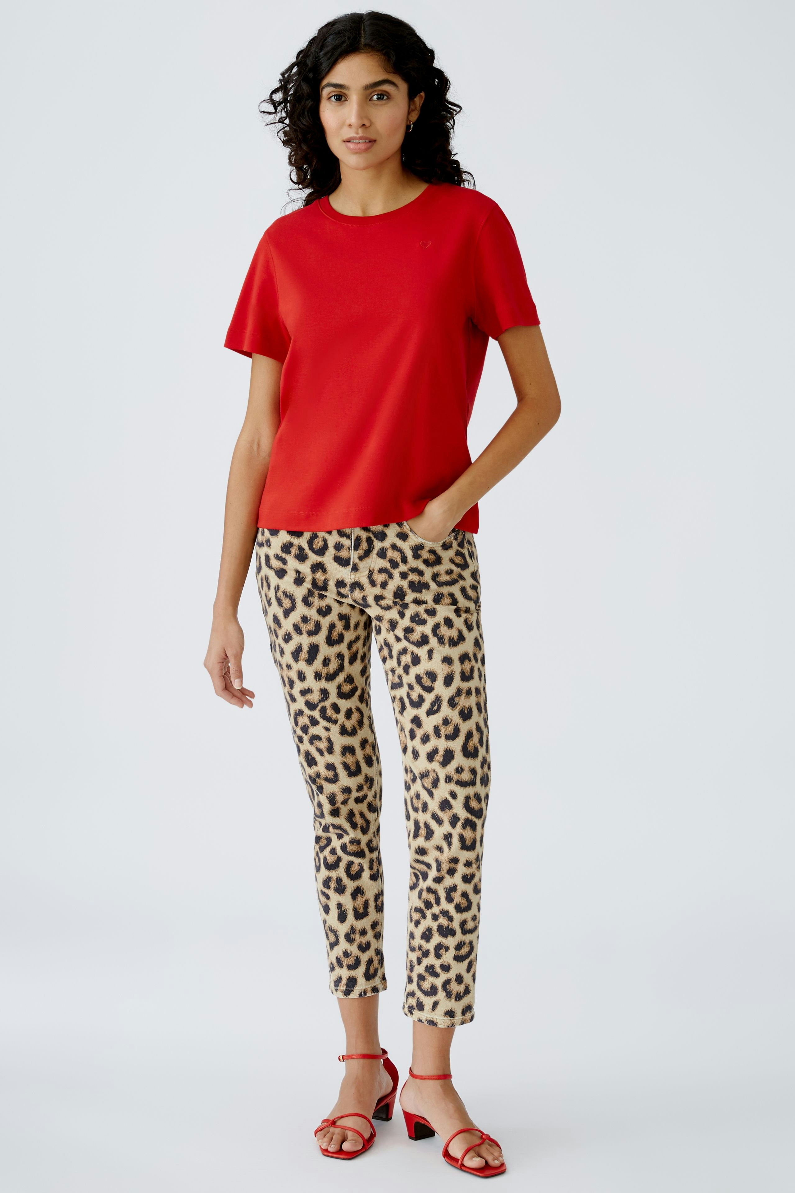Stylish women's T-shirt in vibrant red, paired with trendy leopard print pants.