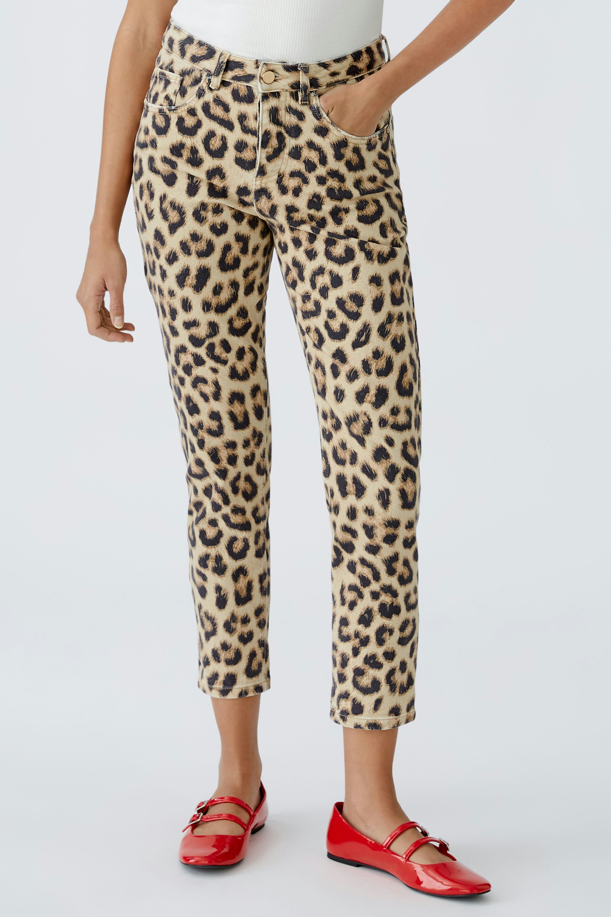 Moderne Damen-Jeans Tapered: Frau in leopardenmuster Jeans mit roten Schuhen und lässigem Look.