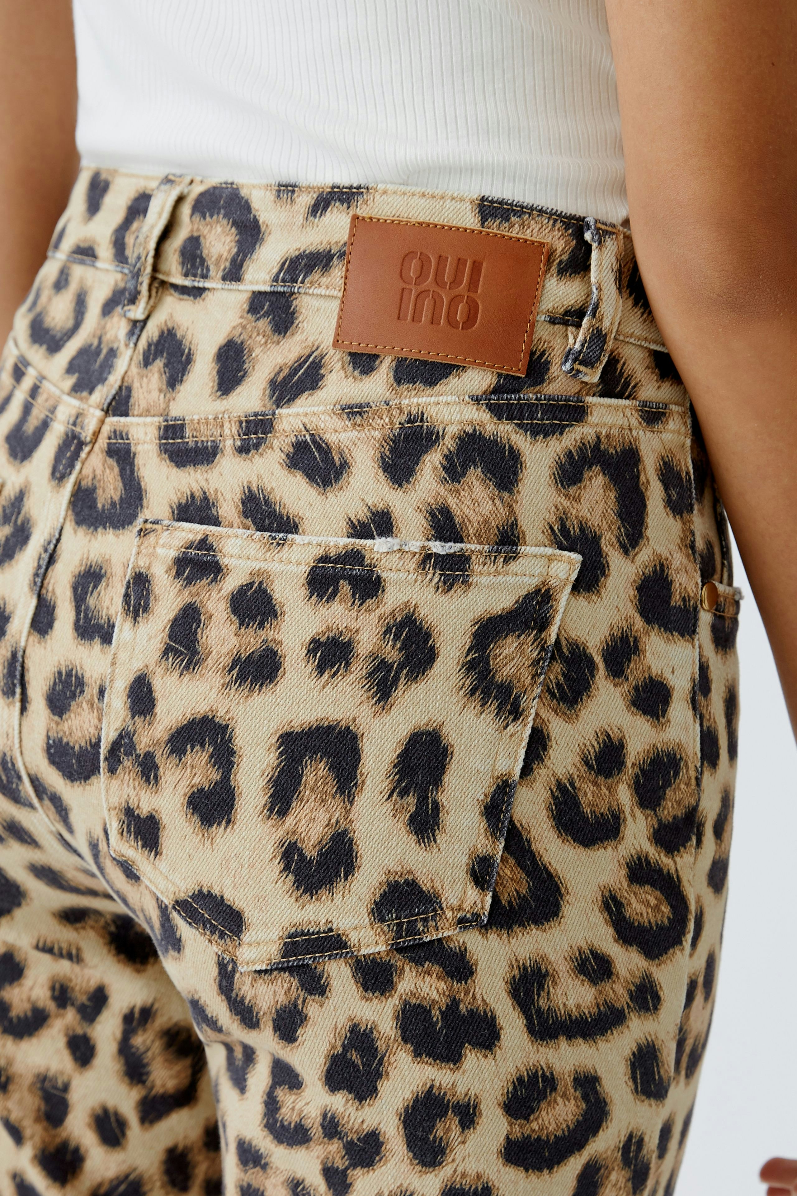 Leopardenmuster Jeans Tapered: Frau trägt modische, figurbetonte Jeans mit auffälligem Muster.