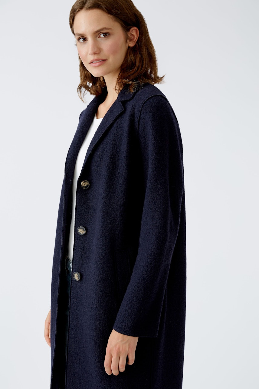 Elegant women's wool coat: A woman in a navy coat with buttons, exuding sophistication and style.