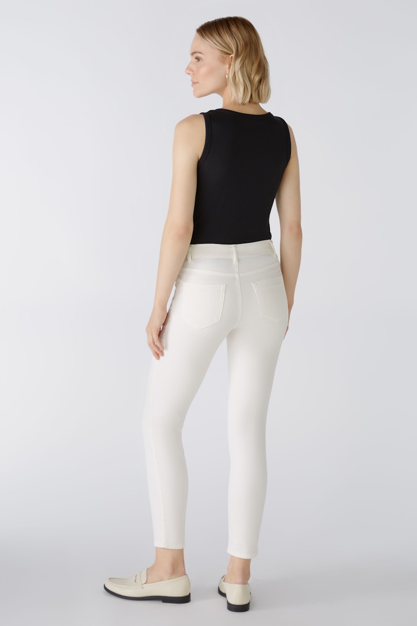 Stylish jeggings: Woman in white jeggings and black top, showcasing a sleek and modern look.