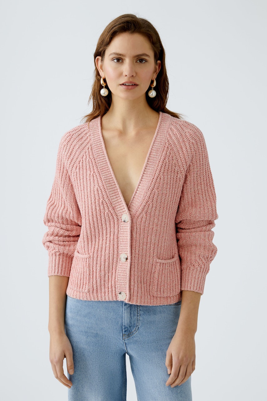 Feminine Strickjacke in zartem Rosa, lässig kombiniert mit Jeans, ideal für den Alltag.