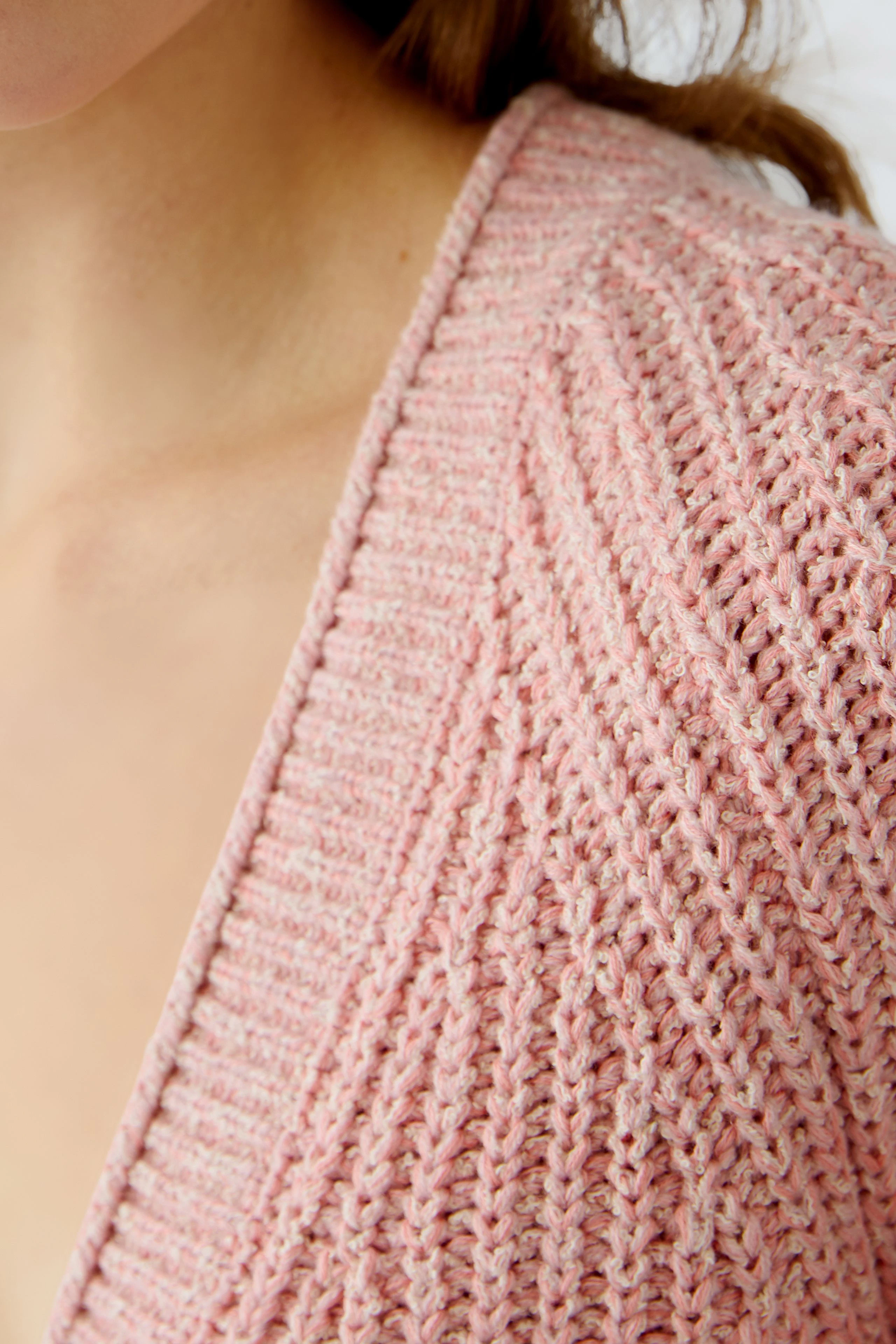 Stylish women's cardigan in soft pink with a textured knit design, perfect for layering.