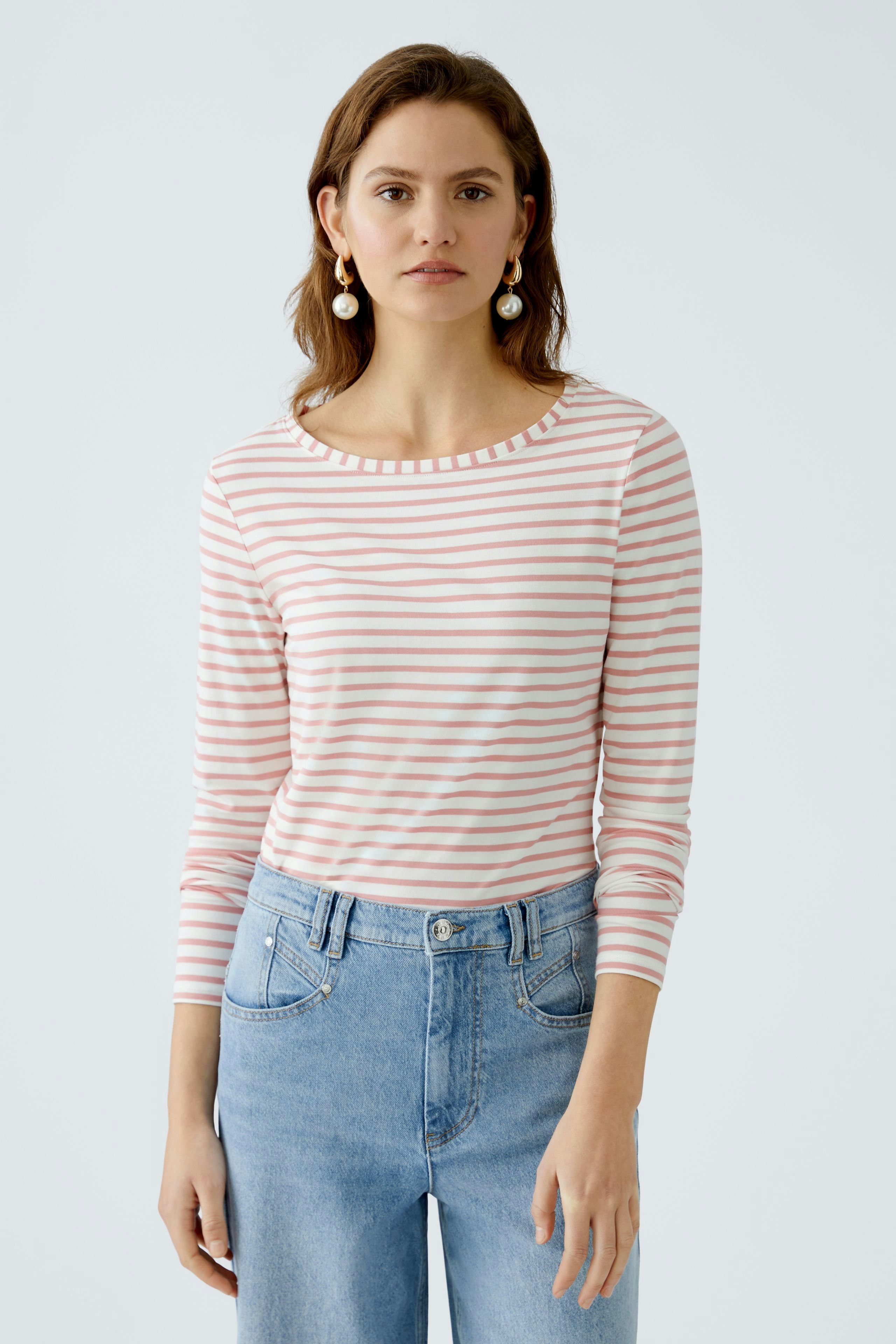 Langarmshirt: Junge Frau in gestreiftem Langarmshirt mit Rundhalsausschnitt und lässiger Jeans.