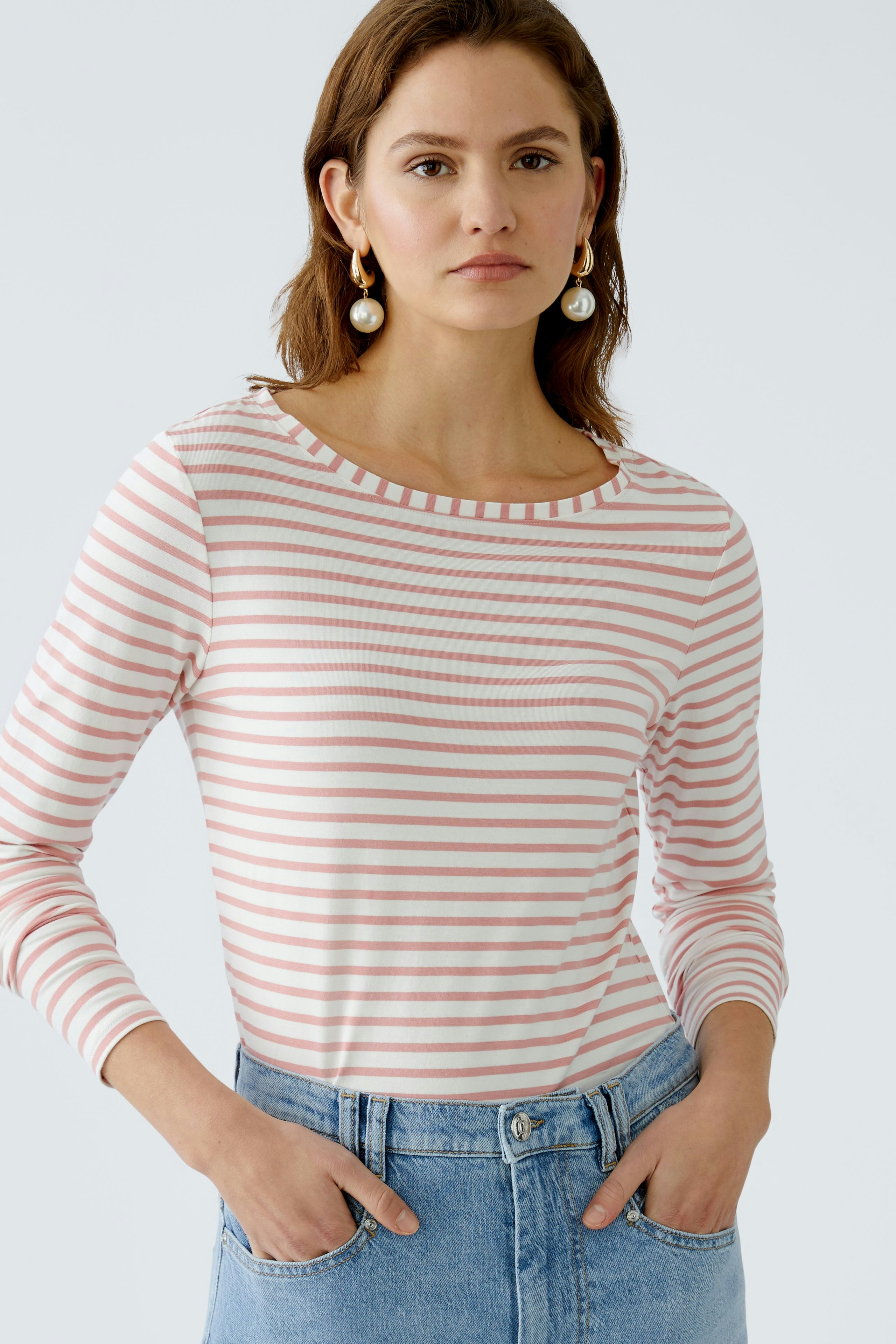 Damen Langarmshirt: Frau in gestreiftem Shirt mit Rundhalsausschnitt und lässiger Jeans.