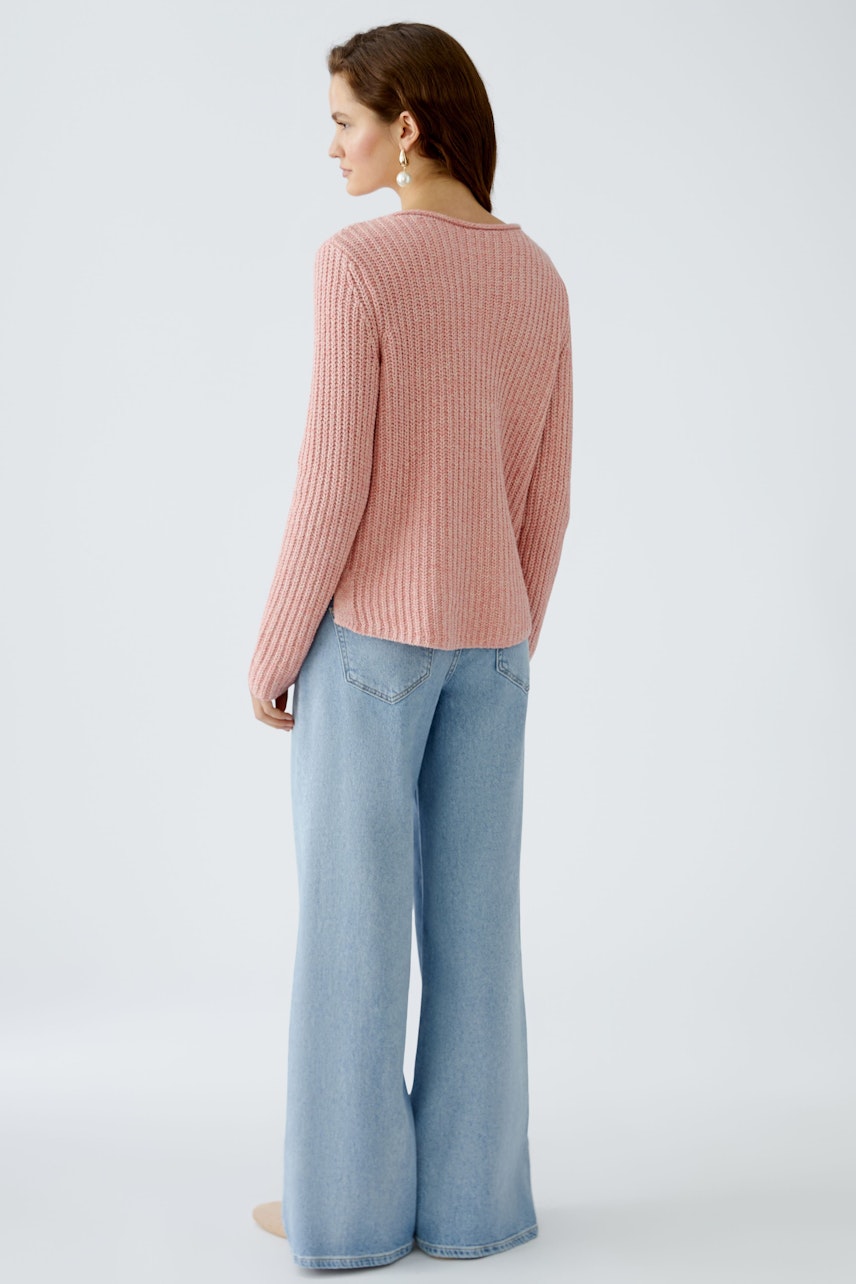 Damen-Pullover: Frau in einem rosa, gerippten Pullover mit lässigem Schnitt und weiten Jeans.