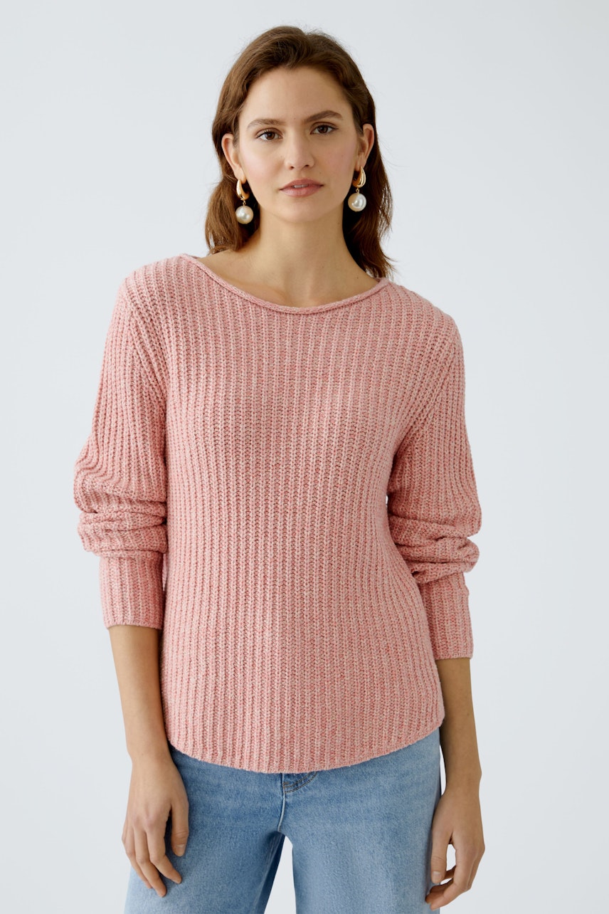 Femininer Pullover: Junge Frau in einem rosa, strukturierten Pullover mit lässigem Schnitt.