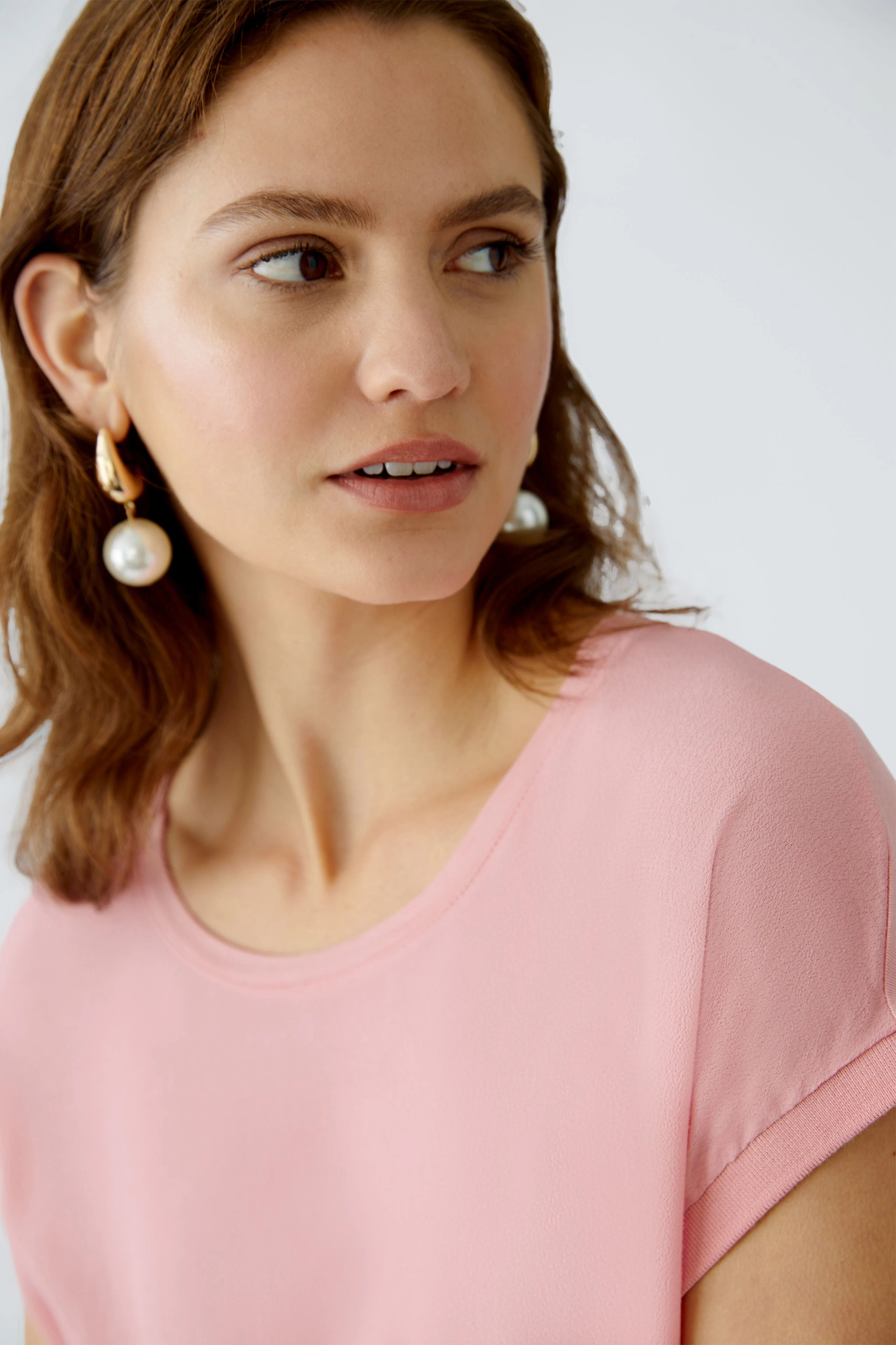 Elegant women's blouse shirt in soft pink, featuring a relaxed fit and round neckline.